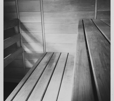 Empty wooden sauna with benches, walls, and benches made of planks.