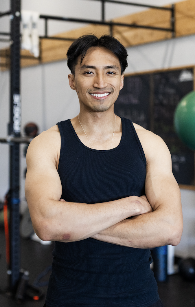Frank Chen, fitness coach, standing in a gym offering personalized training and online coaching