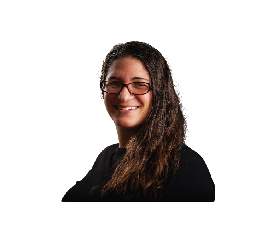 A woman wearing glasses and a black shirt, smiling at the camera with long in dark wavy hair.