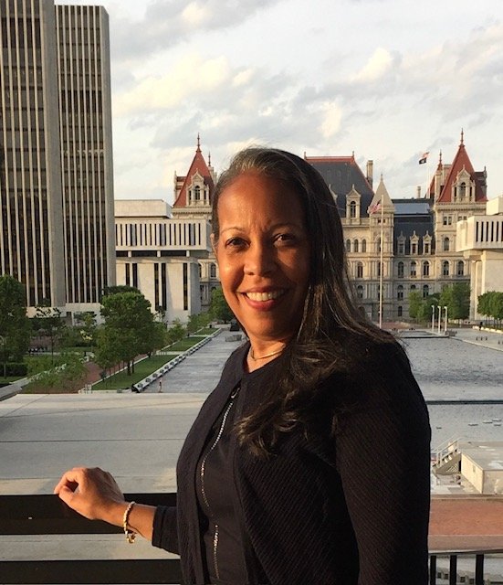 Smiling woman with long hair standing on balcony overlooking capitol building in Nashville, Tennessee.