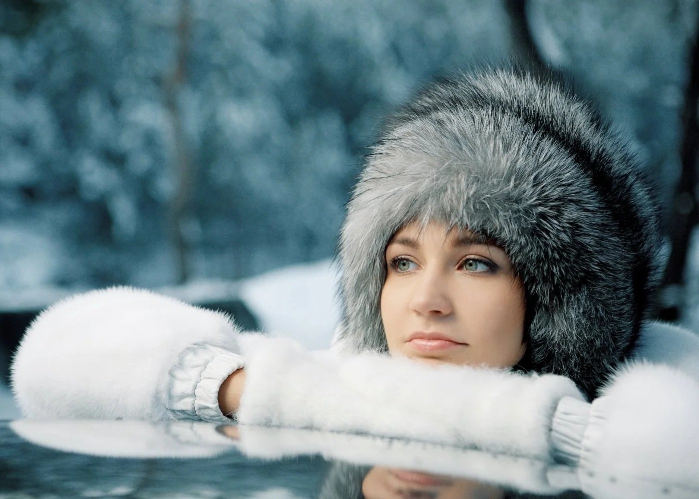 Winter portrait in a fur hat with soft glam makeup and rosy lips
