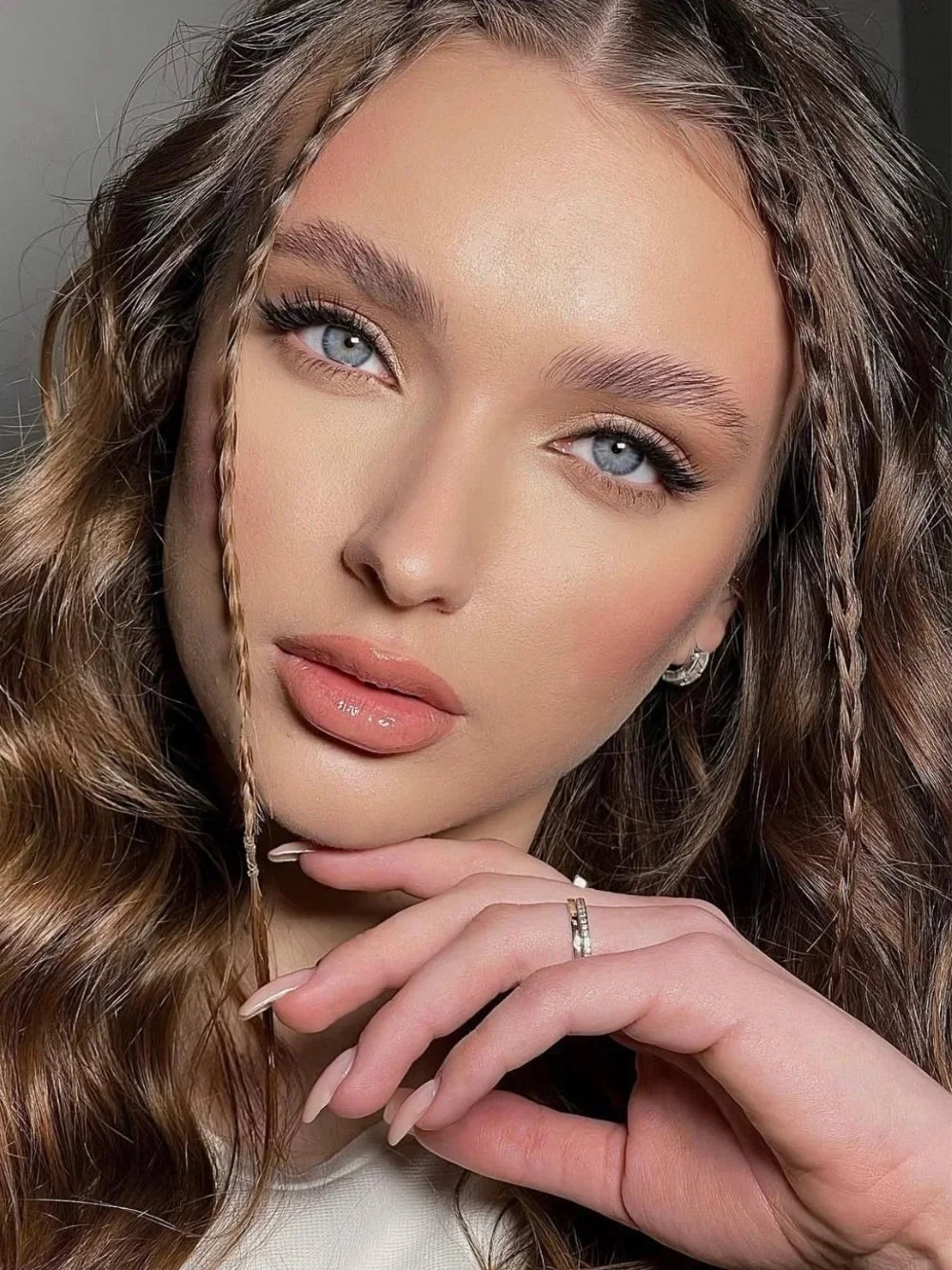 Glowing special occasion makeup with soft glam eyes and nude lips, party confetti backdrop.