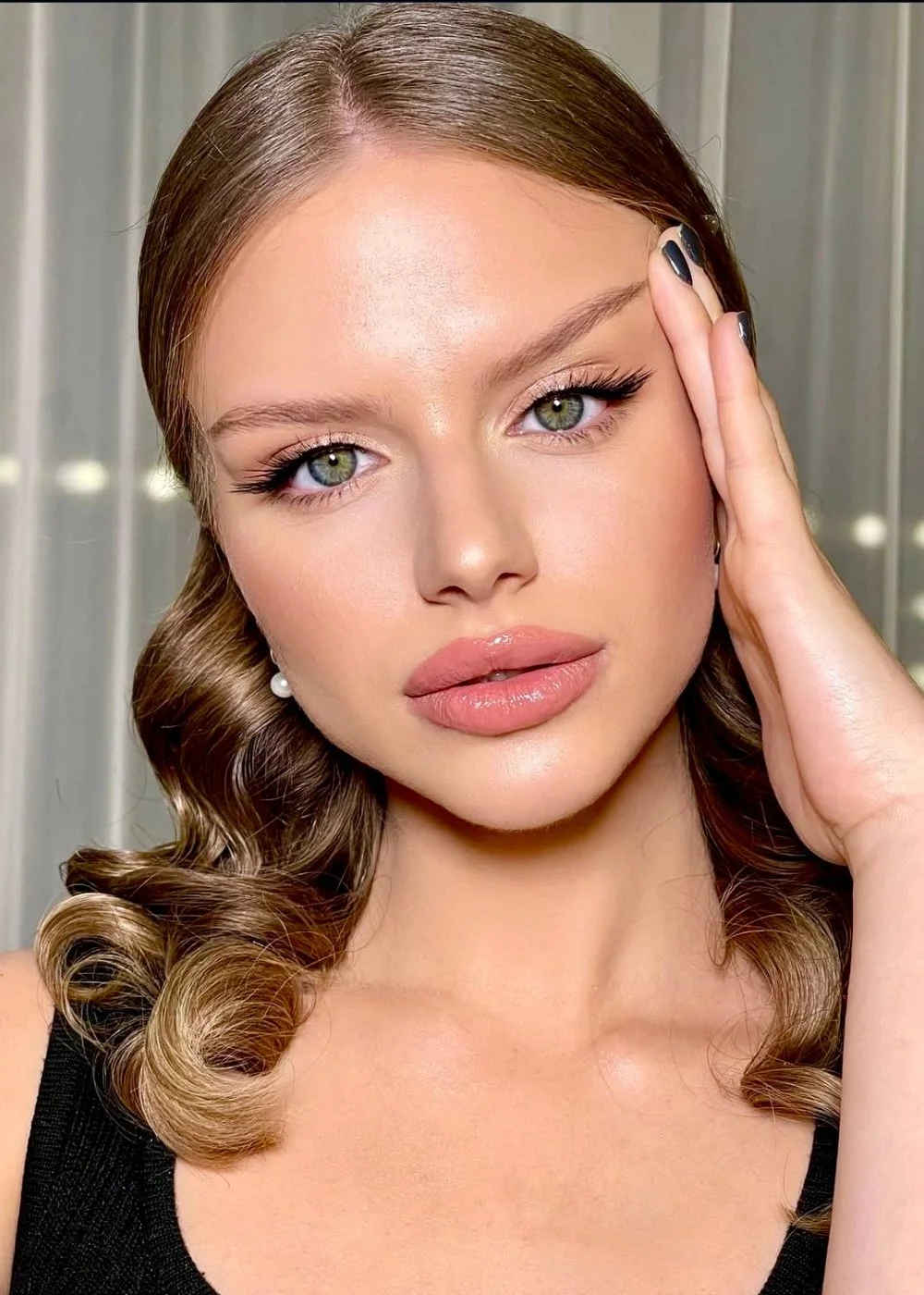Beauty close-up with neutral eyeshadow, glossy lips, and manicured nails