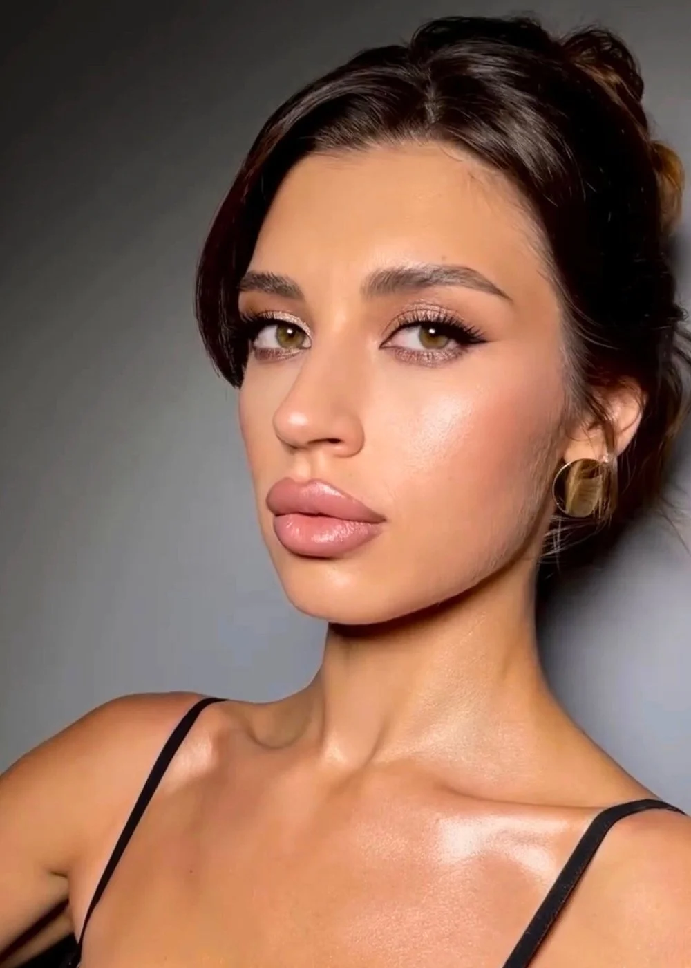 Studio beauty portrait with bronzed glow, sculpted cheekbones, nude lip