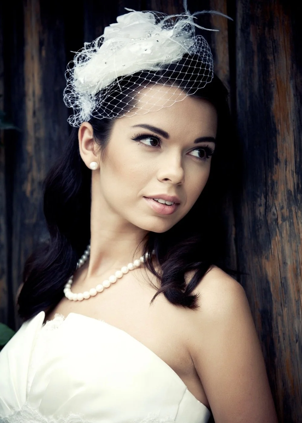 Bridal makeup with soft eyeliner, porcelain skin, and classic pearls