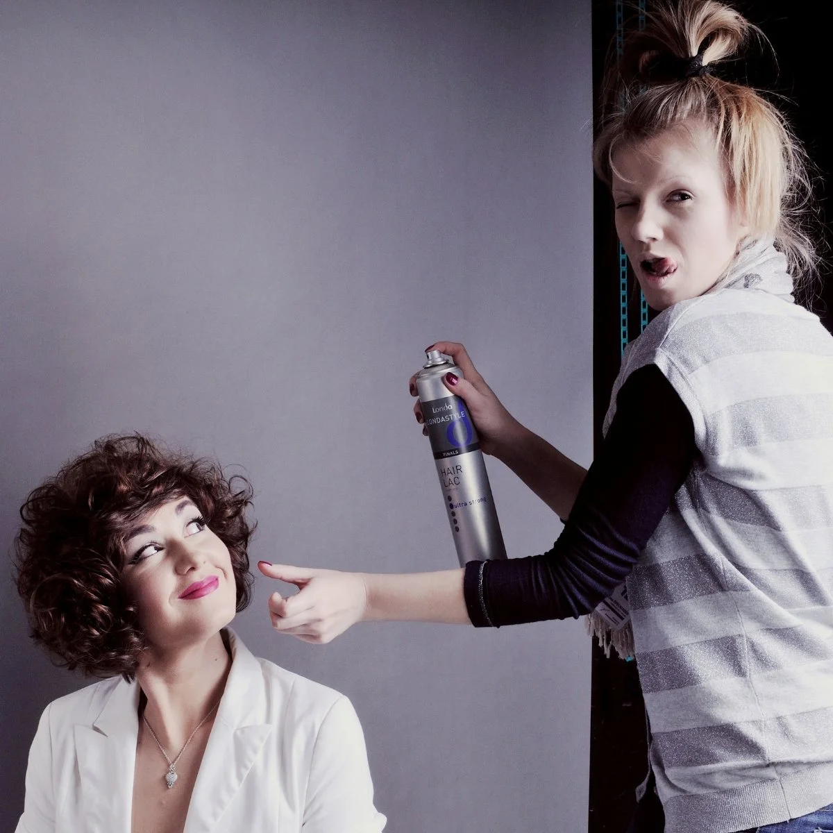 Touch-up and hairspray on a model during a studio shoot