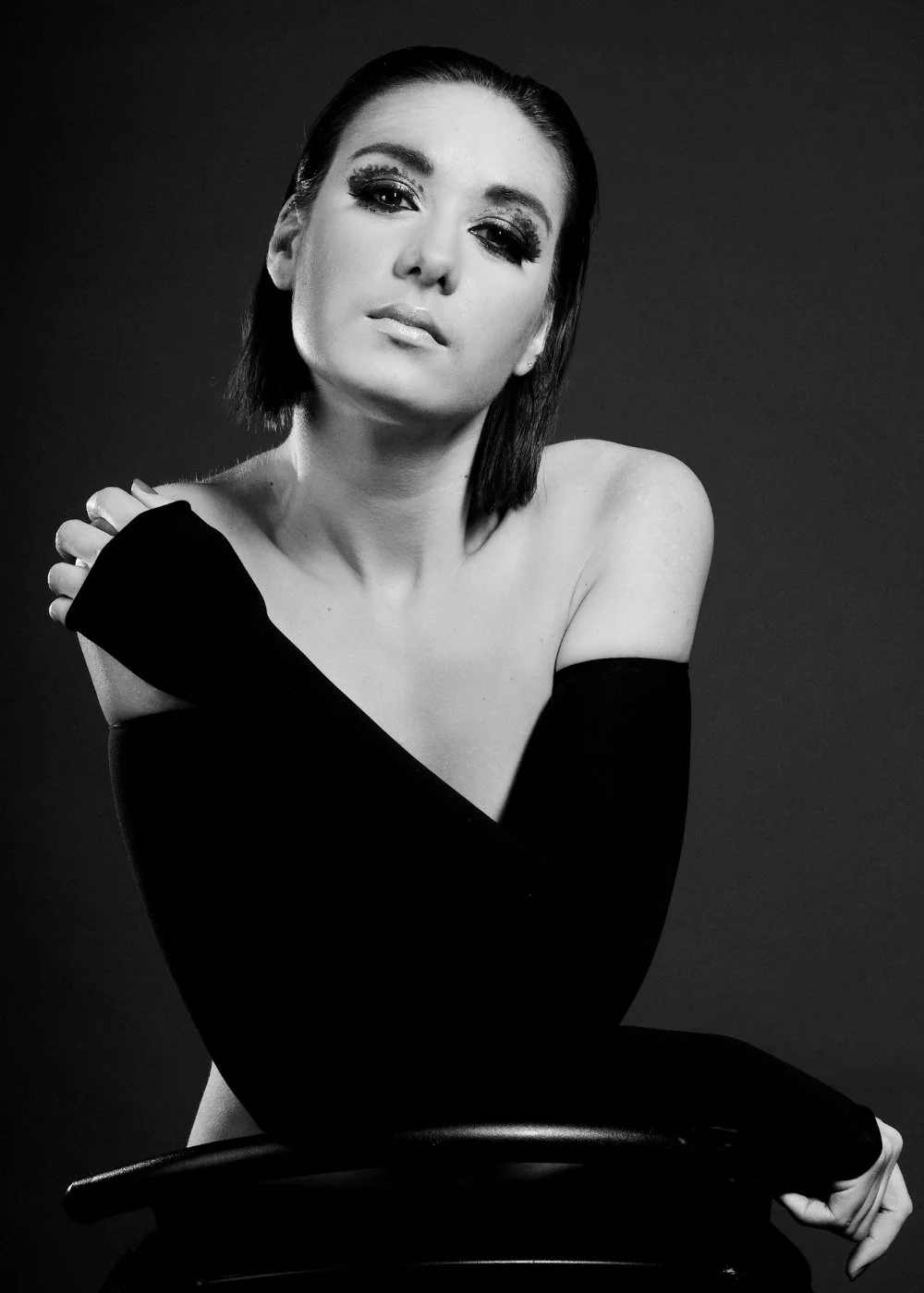 Black-and-white portrait with off-shoulder top and dramatic eye makeup