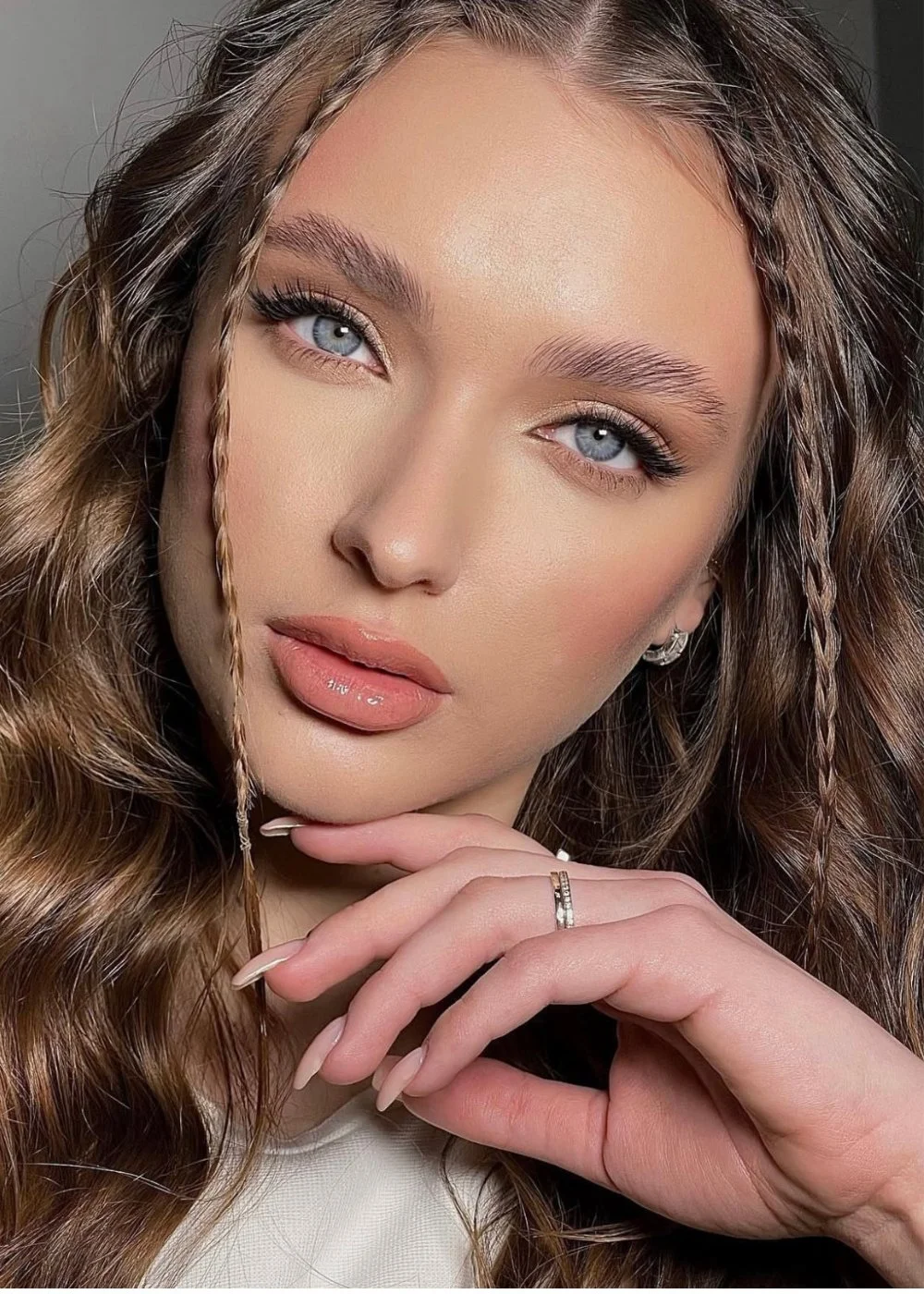 Special occasion makeup with glowing skin, nude lip, and soft waves