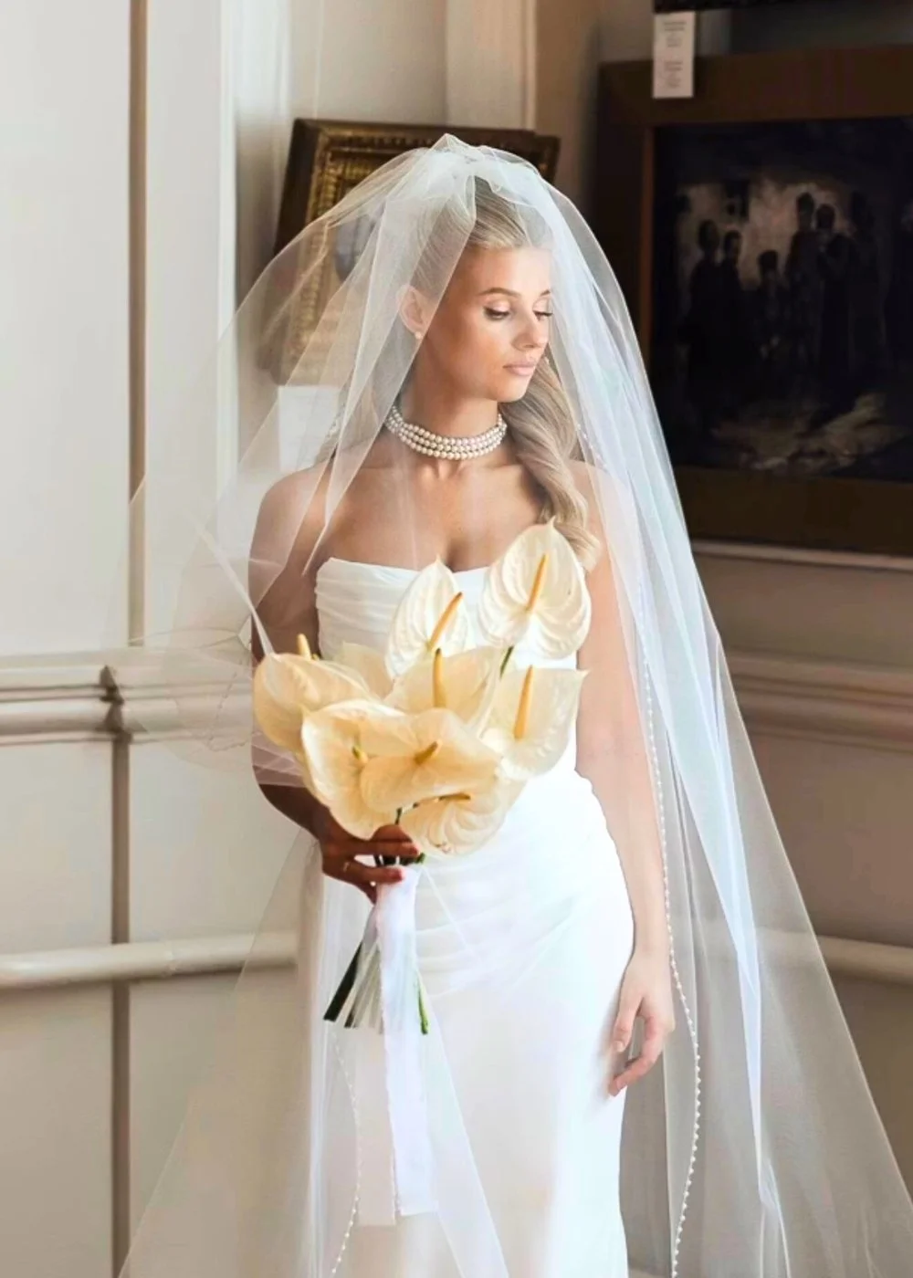 Bride in veil holding calla lilies, elegant bridal makeup