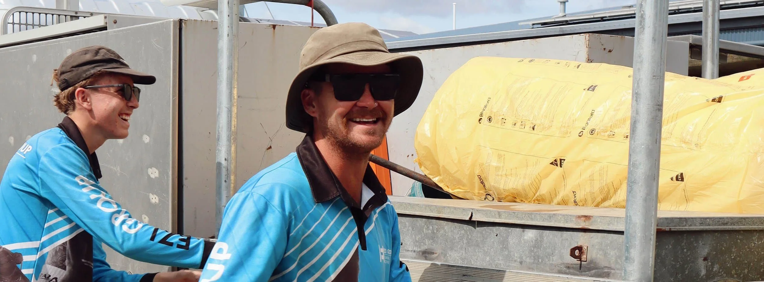 A photo of Michael and Lachy from Ezi Group smiling while working.