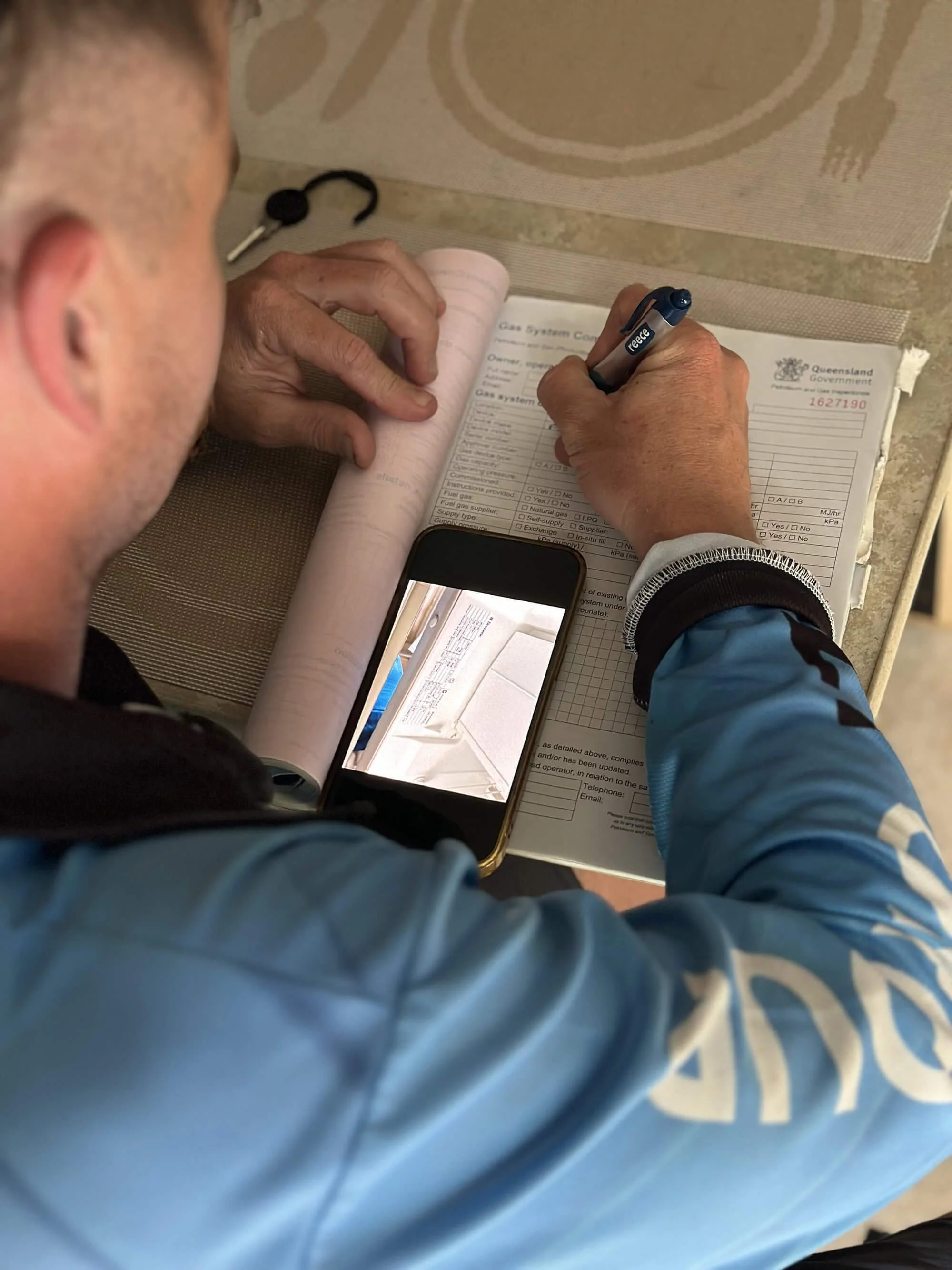 A photo of Ezi Group's Michael filling out a Gas Systems Compliance certificate for a customer.