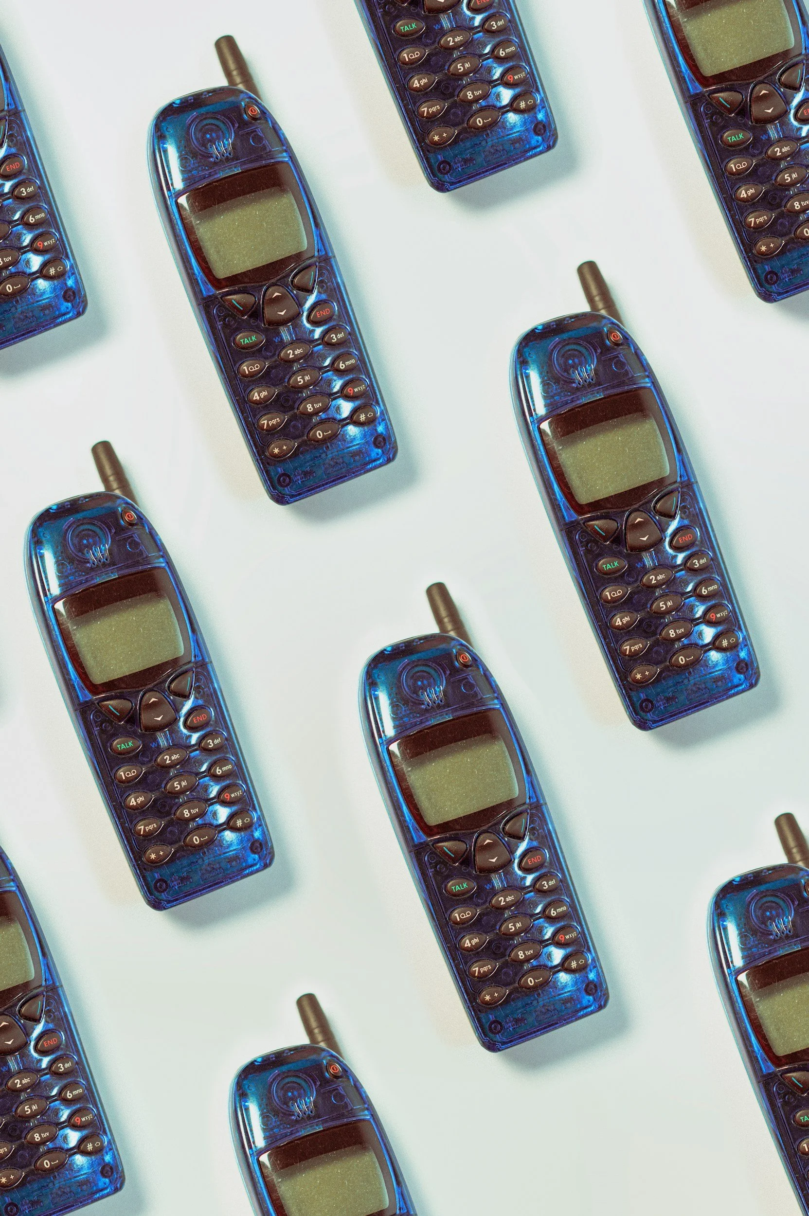 Multiple blue cordless phones arranged on a white background.