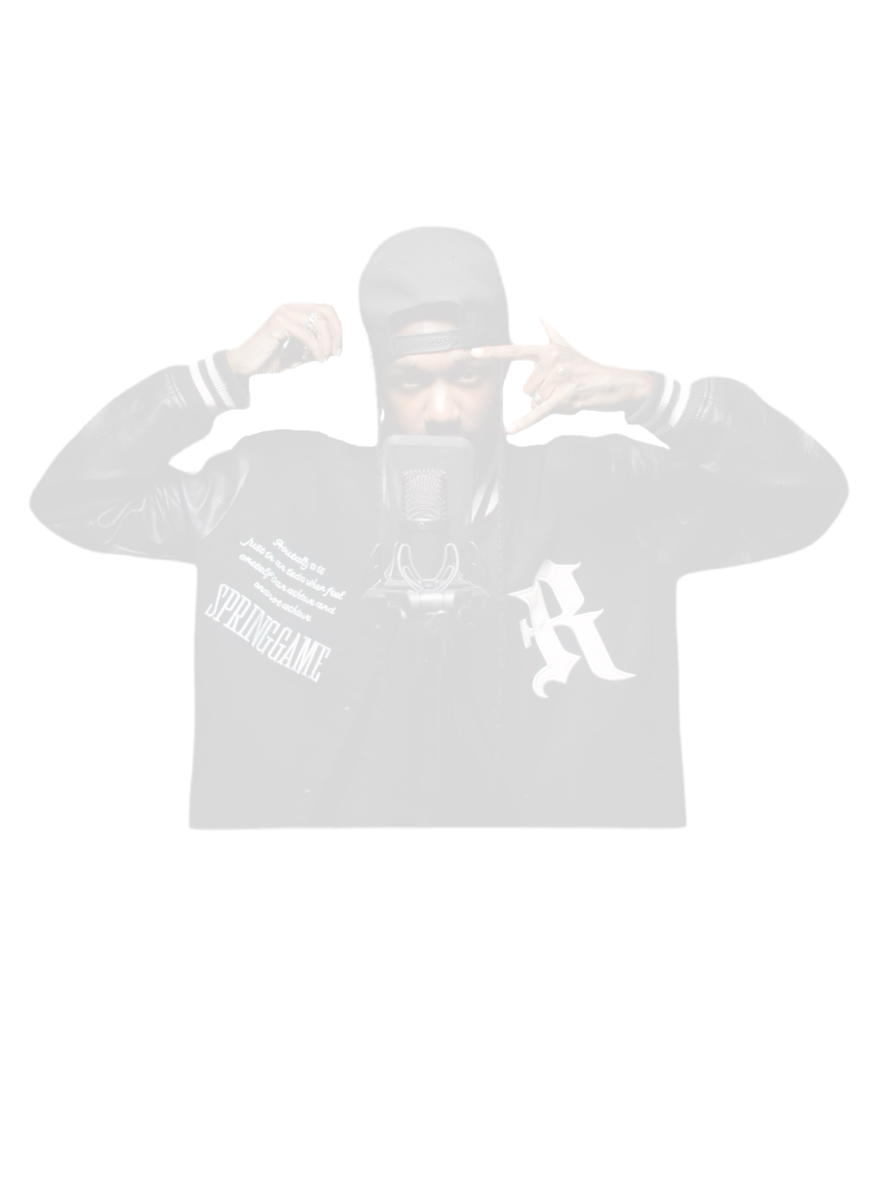 A person in a black baseball cap and black jacket making a gesture with both hands near his head in front of a microphone.