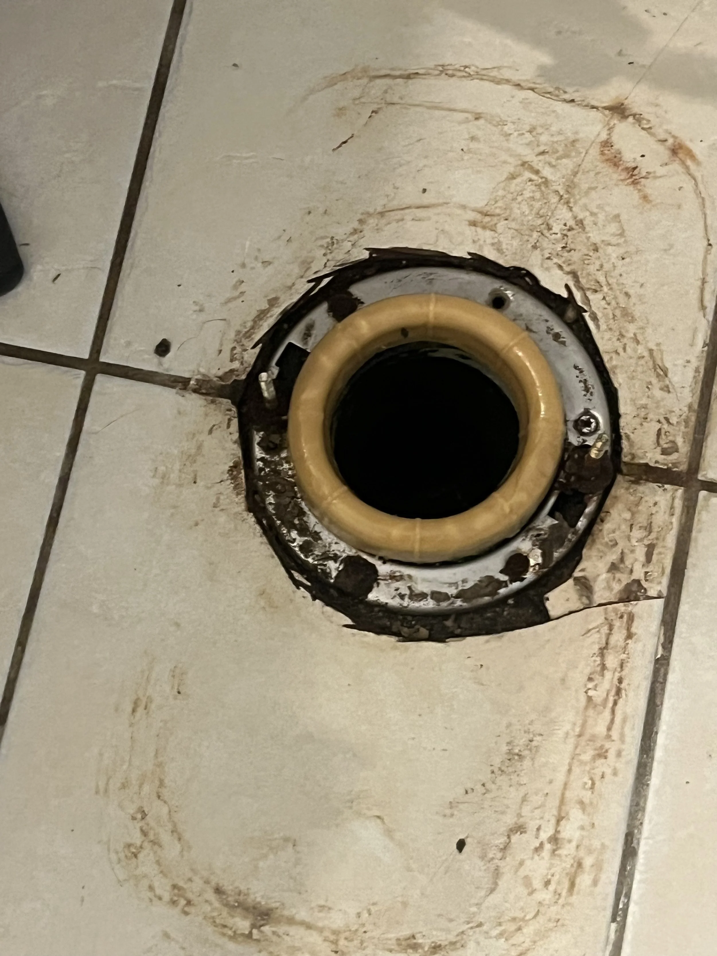 A toilet flange with a yellow wax ring installed