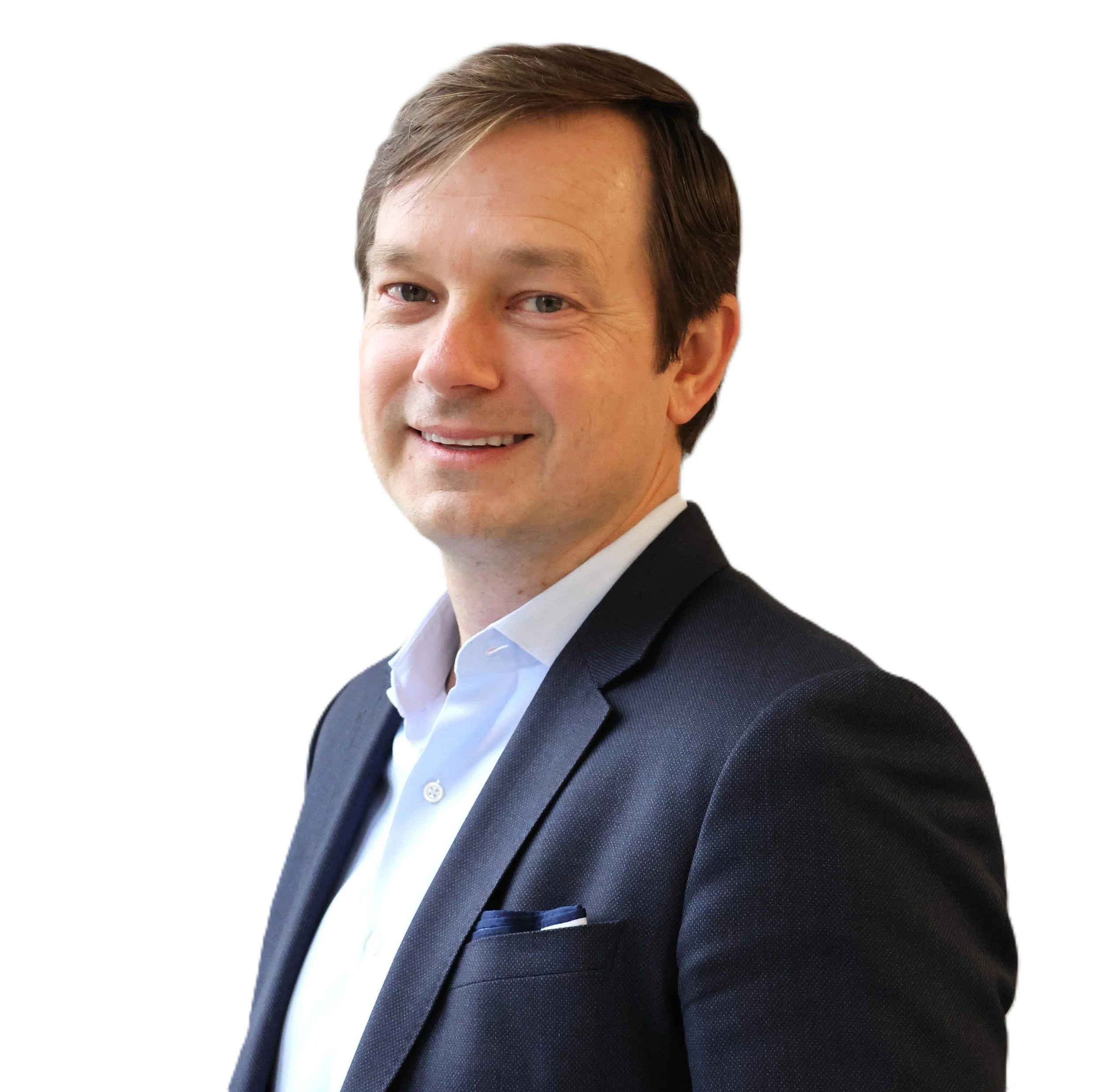 Professional man in a dark suit and white shirt smiling, facing slightly right, with a white background.
