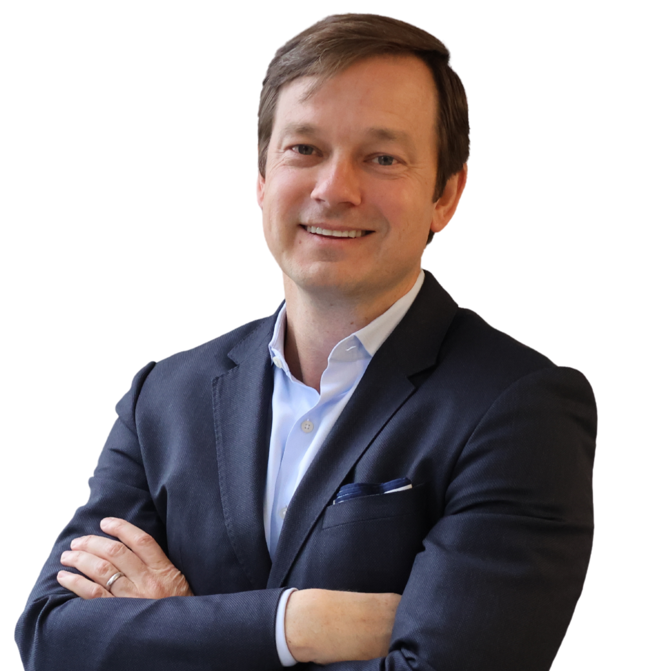 A smiling man with brown hair in a dark suit and white shirt, crossing his arms, standing against a white background.