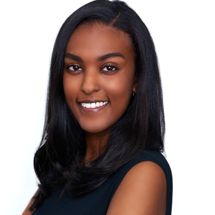 A portrait of a young African American woman with straight black hair, smiling, wearing a sleeveless black top, against a plain white background.