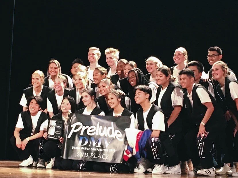 Group of young dancers on stage holding a banner that reads 'Prelude DMV' and '2nd Place' after a dance competition.