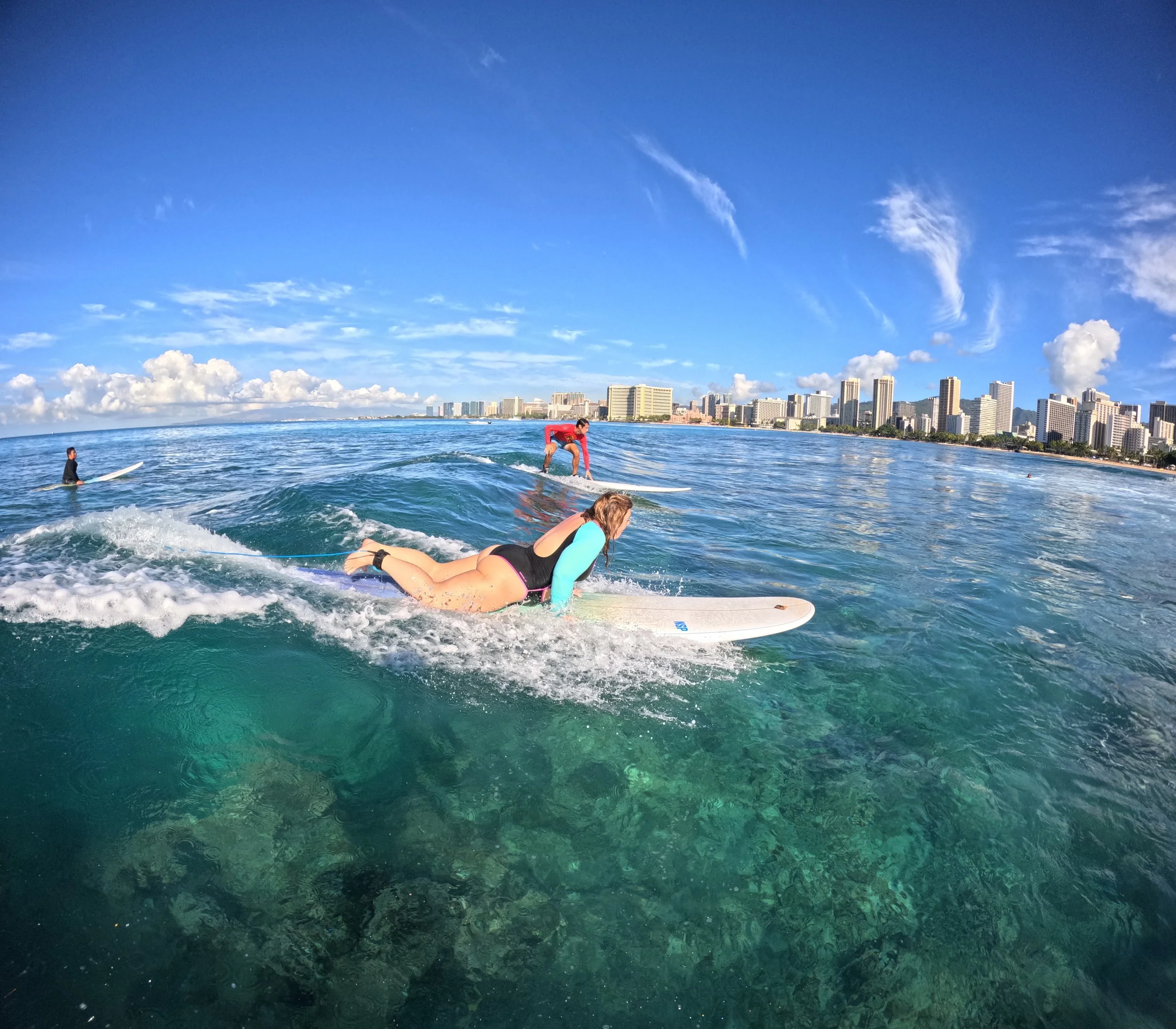 SURFER CASS POPPING UP ON A BOARD IN WAIKIKI ON OAHU ON A SMALL WAVE
