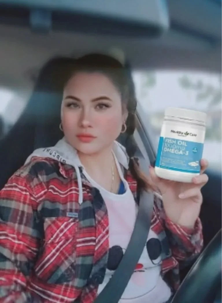 Woman in a car holding a bottle of fish oil supplements