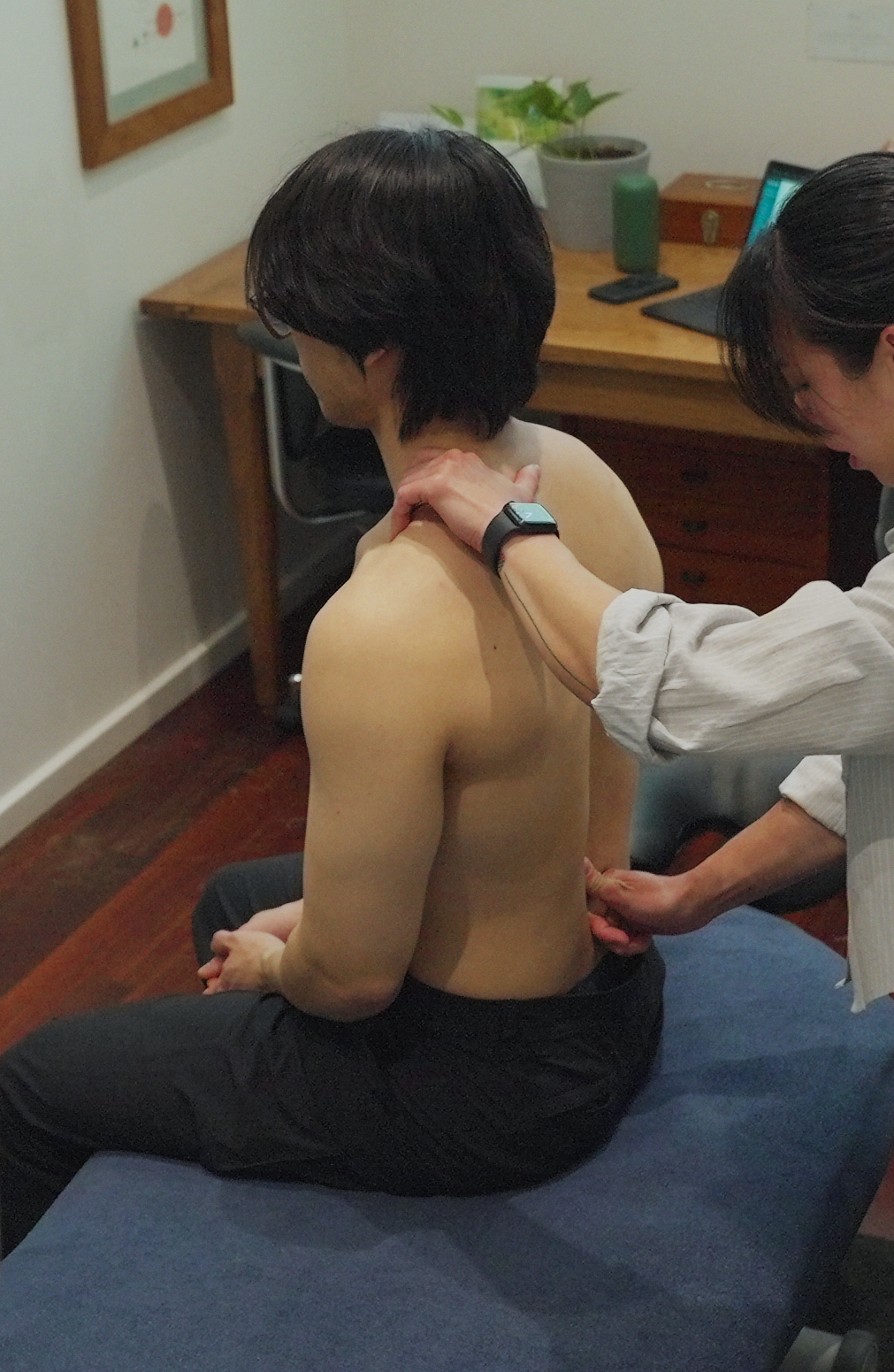 A patient with back pain and neck pain getting a chiropractor to assess his issues and he is having a physical assessment.