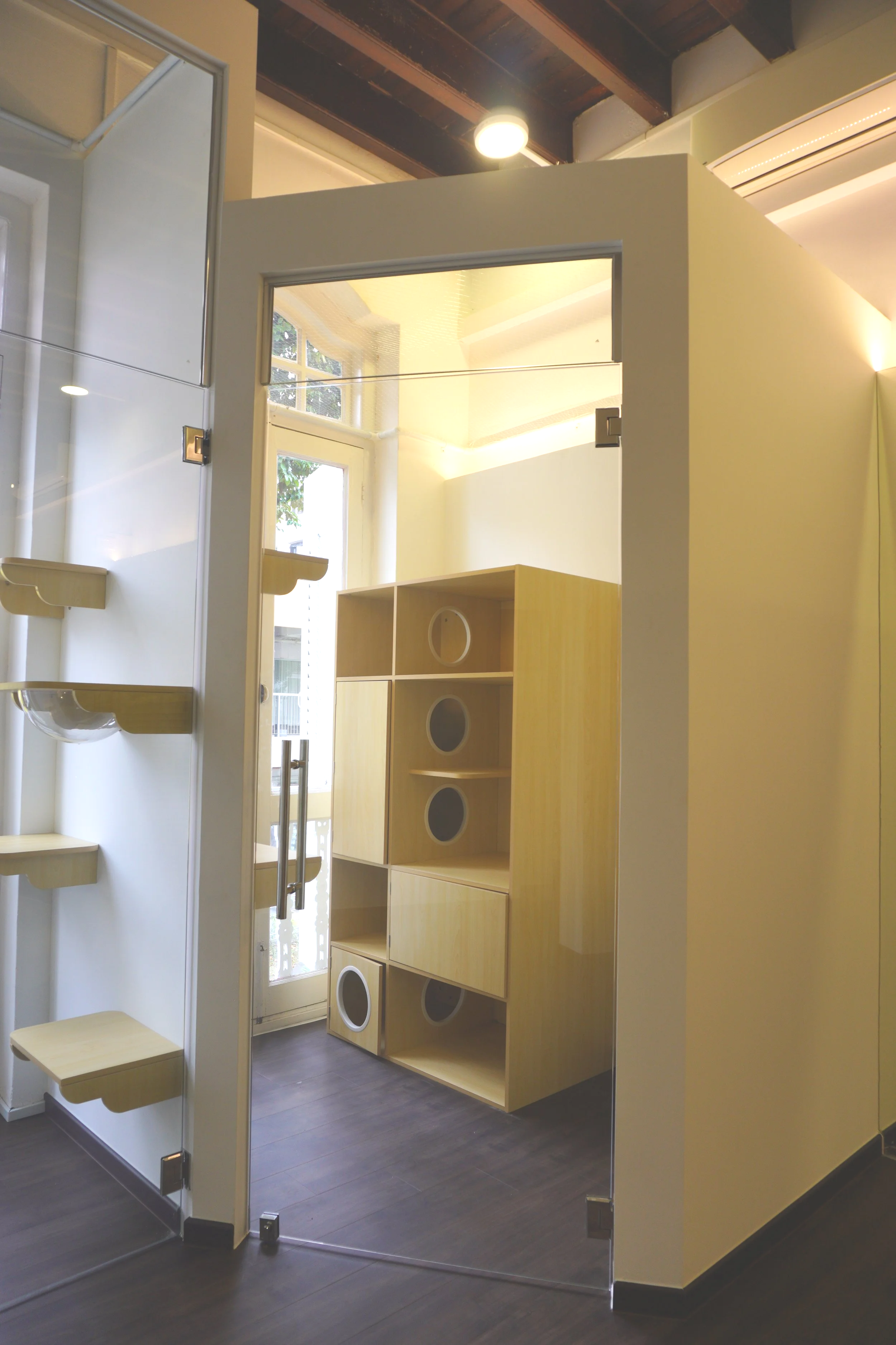 Interior of the expansive Premium Villa family suite at Kuro Cat Hotel Singapore, equipped with a large multi-level wooden cat condo.