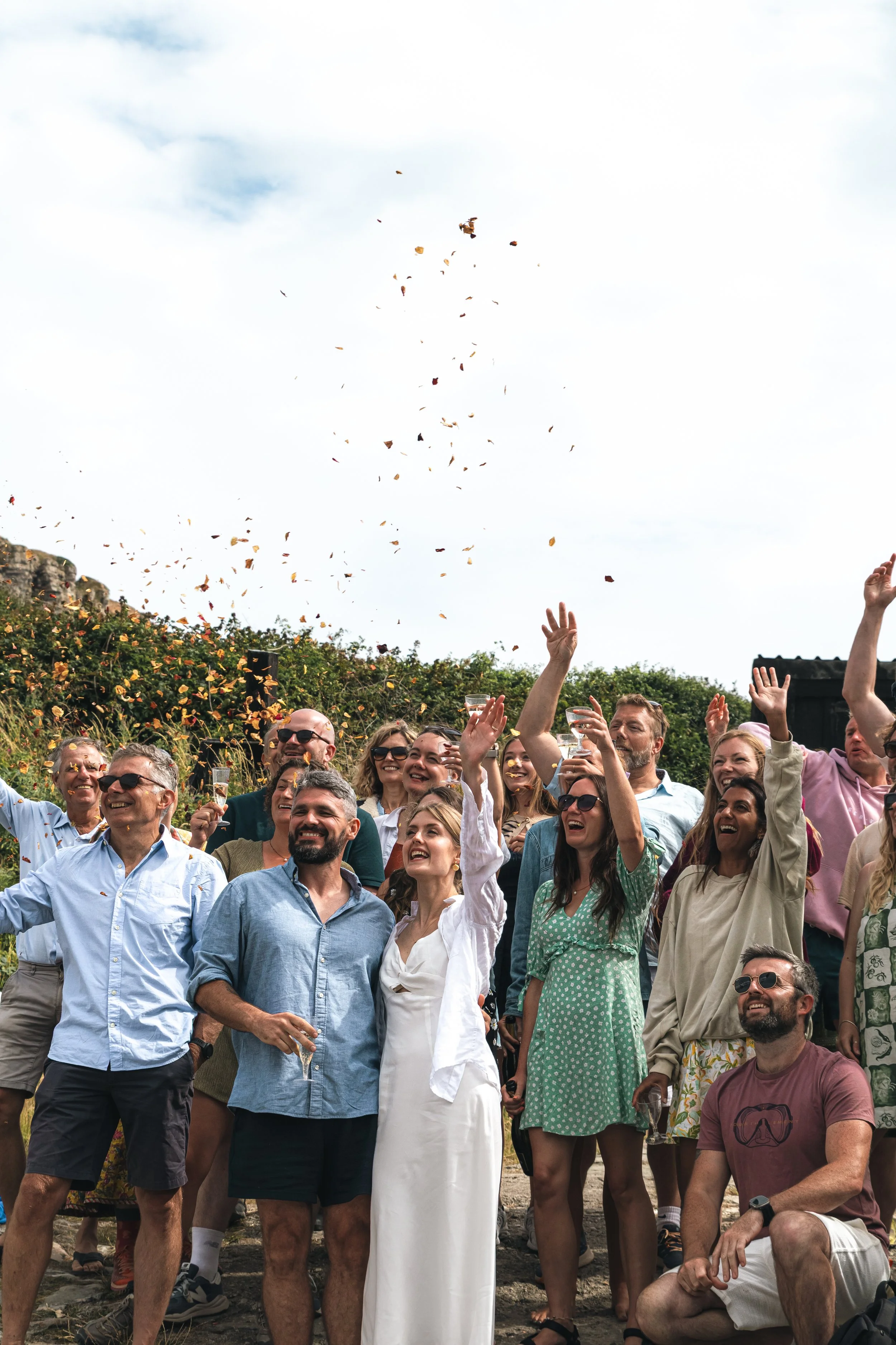 Wedding guests celebrating and throwing confetti at a Dorset wedding, captured in a candid, joyful moment.