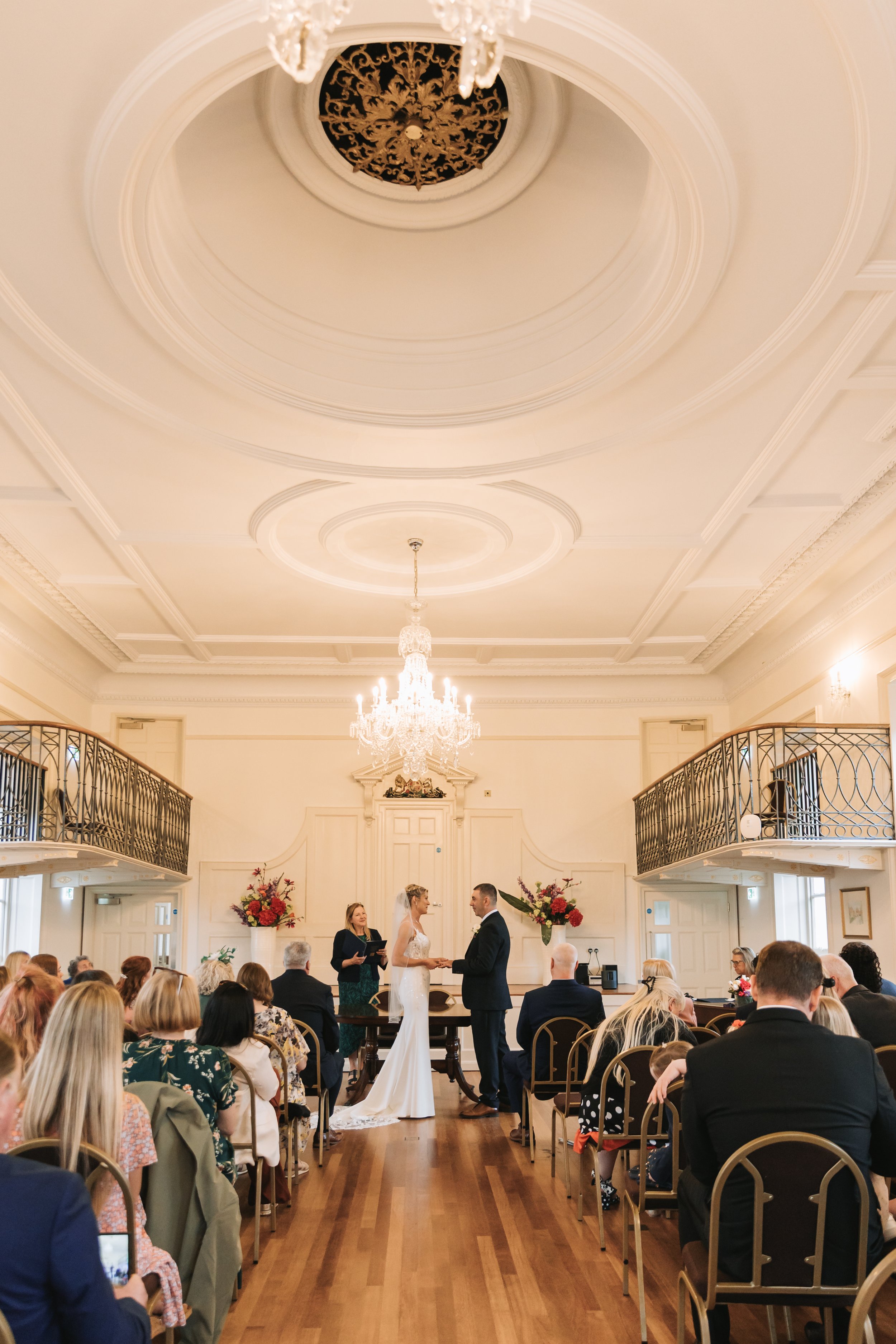 Bride and groom hand in hand during wedding ceremony at Poole Guildhall, Dorset