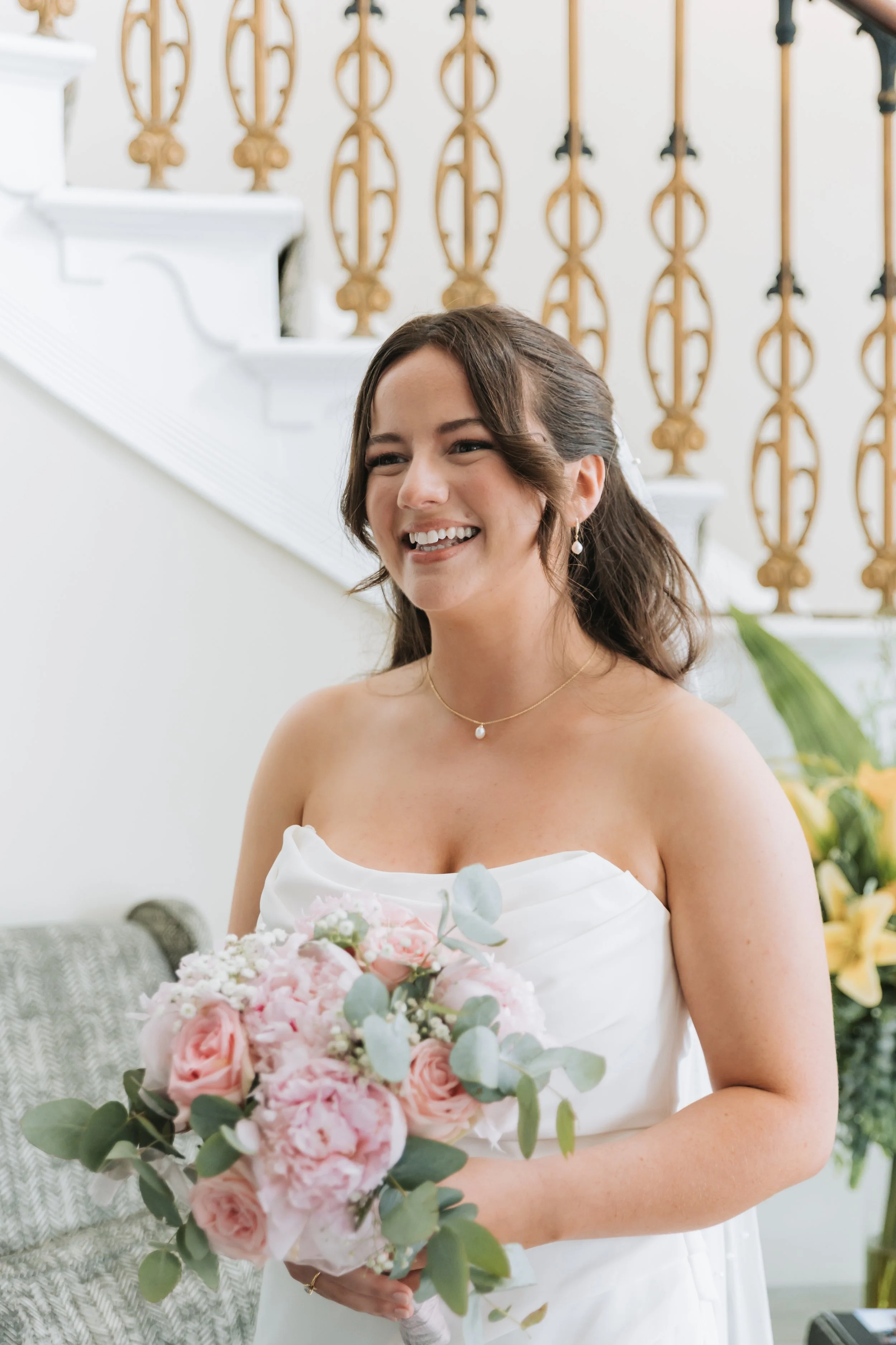 A smiling bride with a bouquet of flowers before the wedding ceremony at the Harbour Hotel in Chichester.