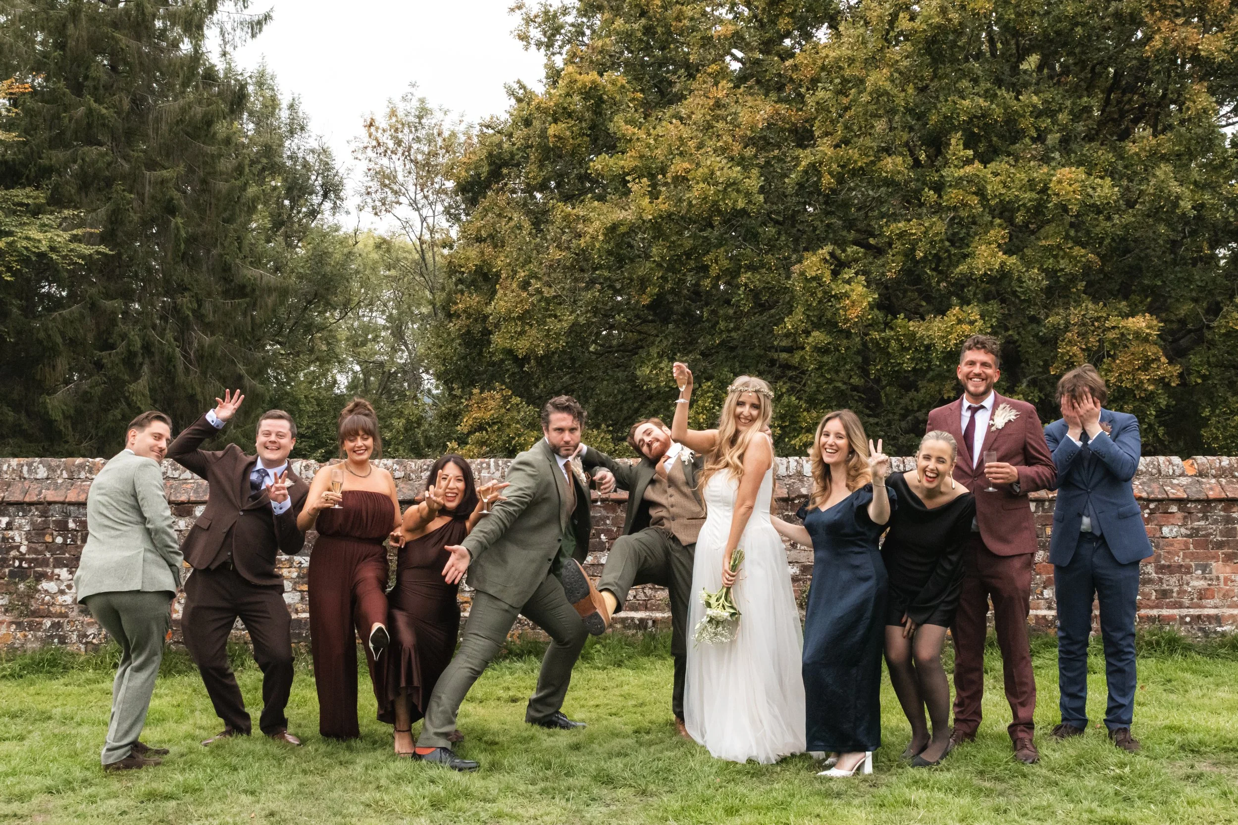 Bride and groom having fun with their bridesmaids and groomsmen at a Dorset wedding, captured in a playful, candid group photo.