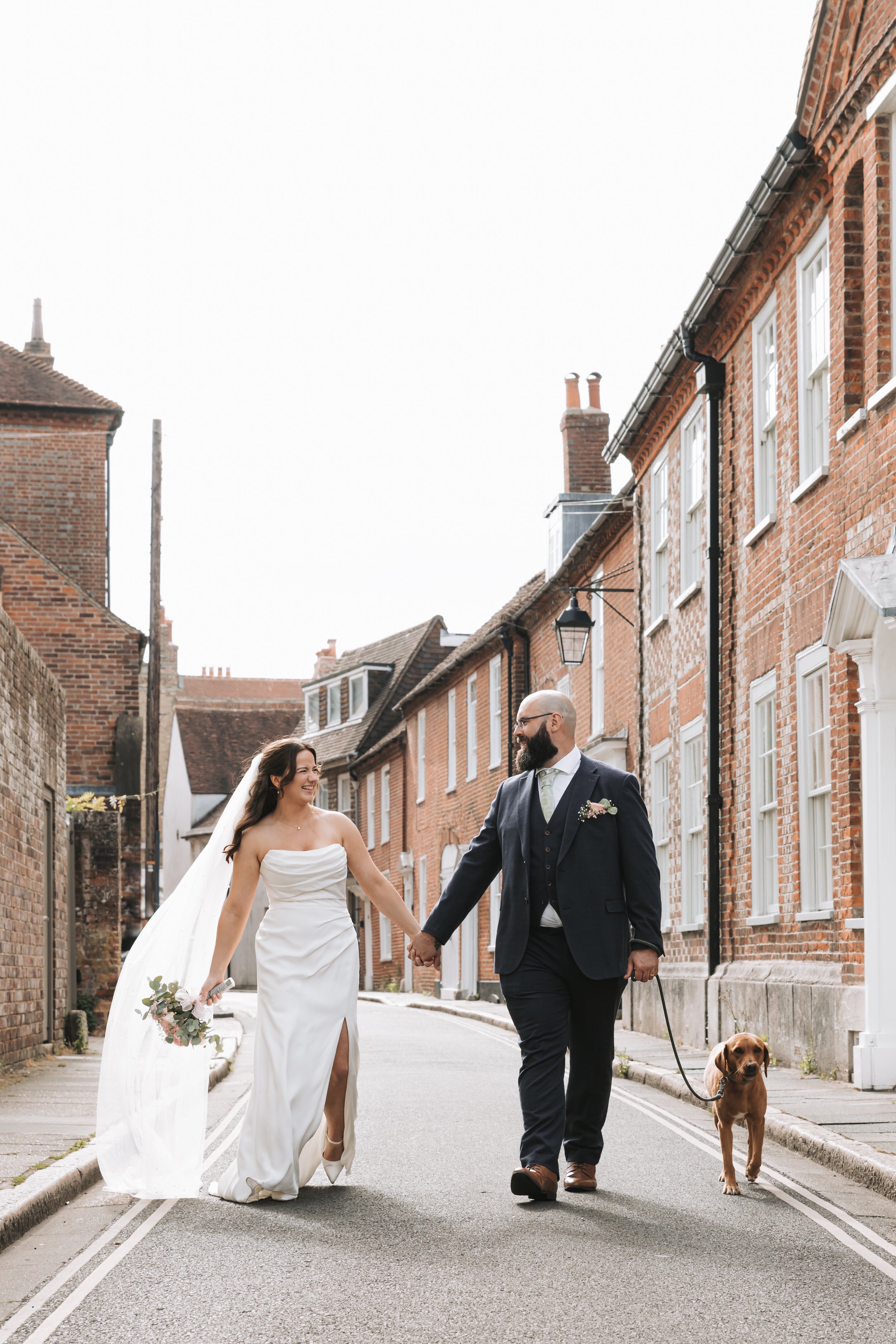 Bride and groom on their wedding day walking on the streets of Chichester. 