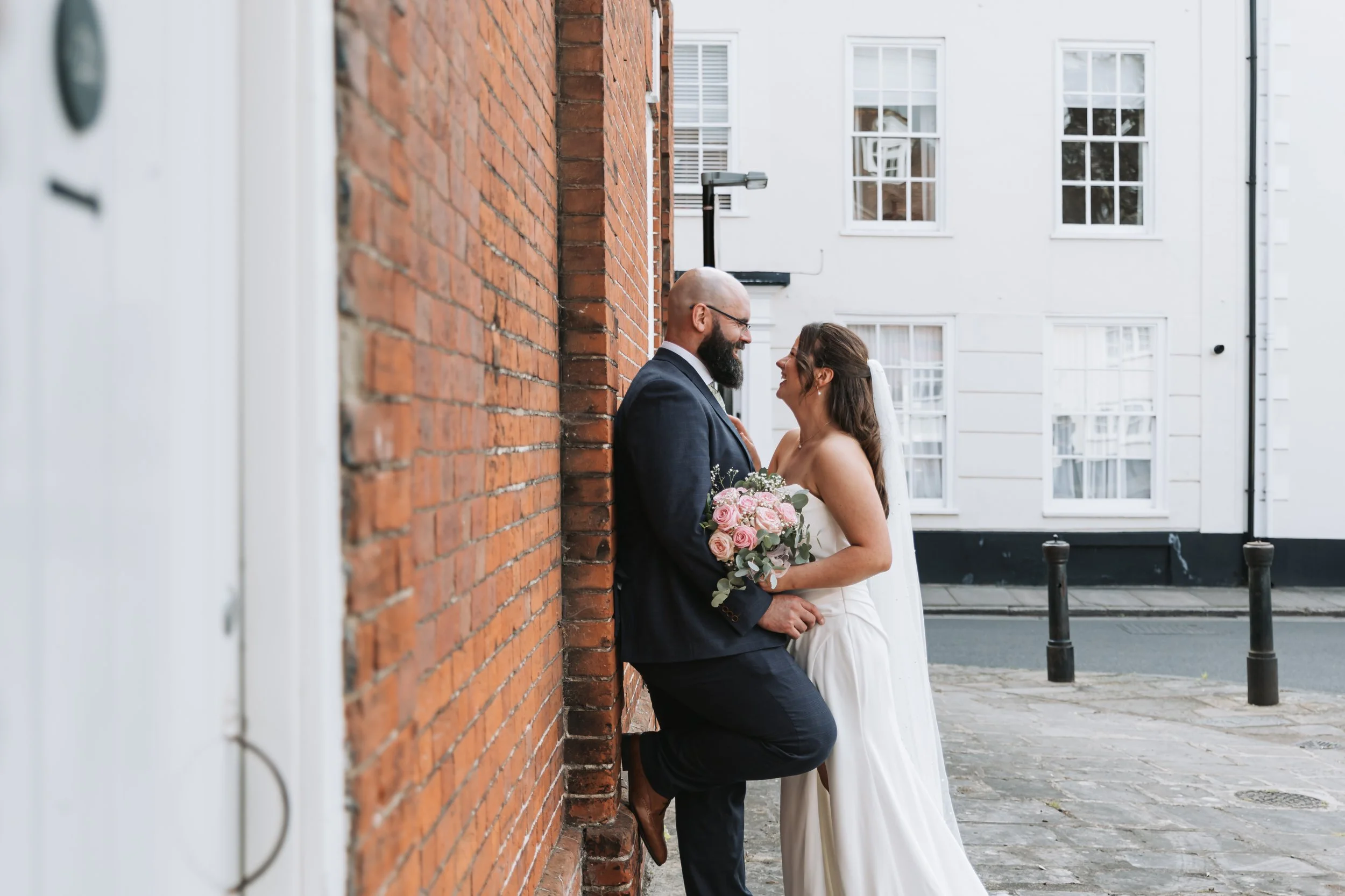 Wedding couple portrait on streets of Chichester. Bride and groom looking romantic.