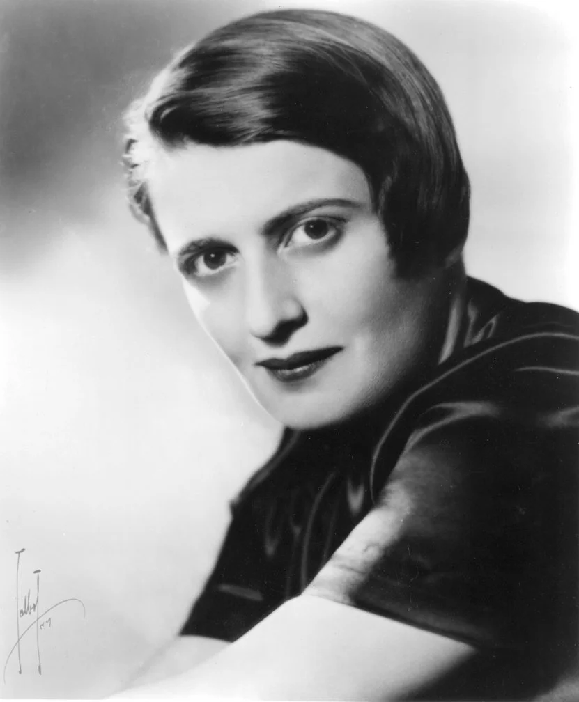Black and white portrait of a woman with short hair, looking directly at the camera with a slight smile.