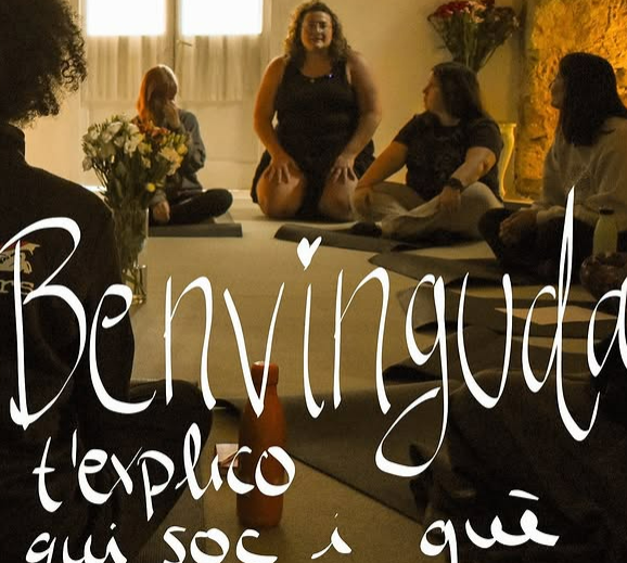 Grupo de personas sentadas en círculo en un ambiente acogedor con una mujer en el centro, texto que dice 'Bienvenida te explico aquí soy a qué'.