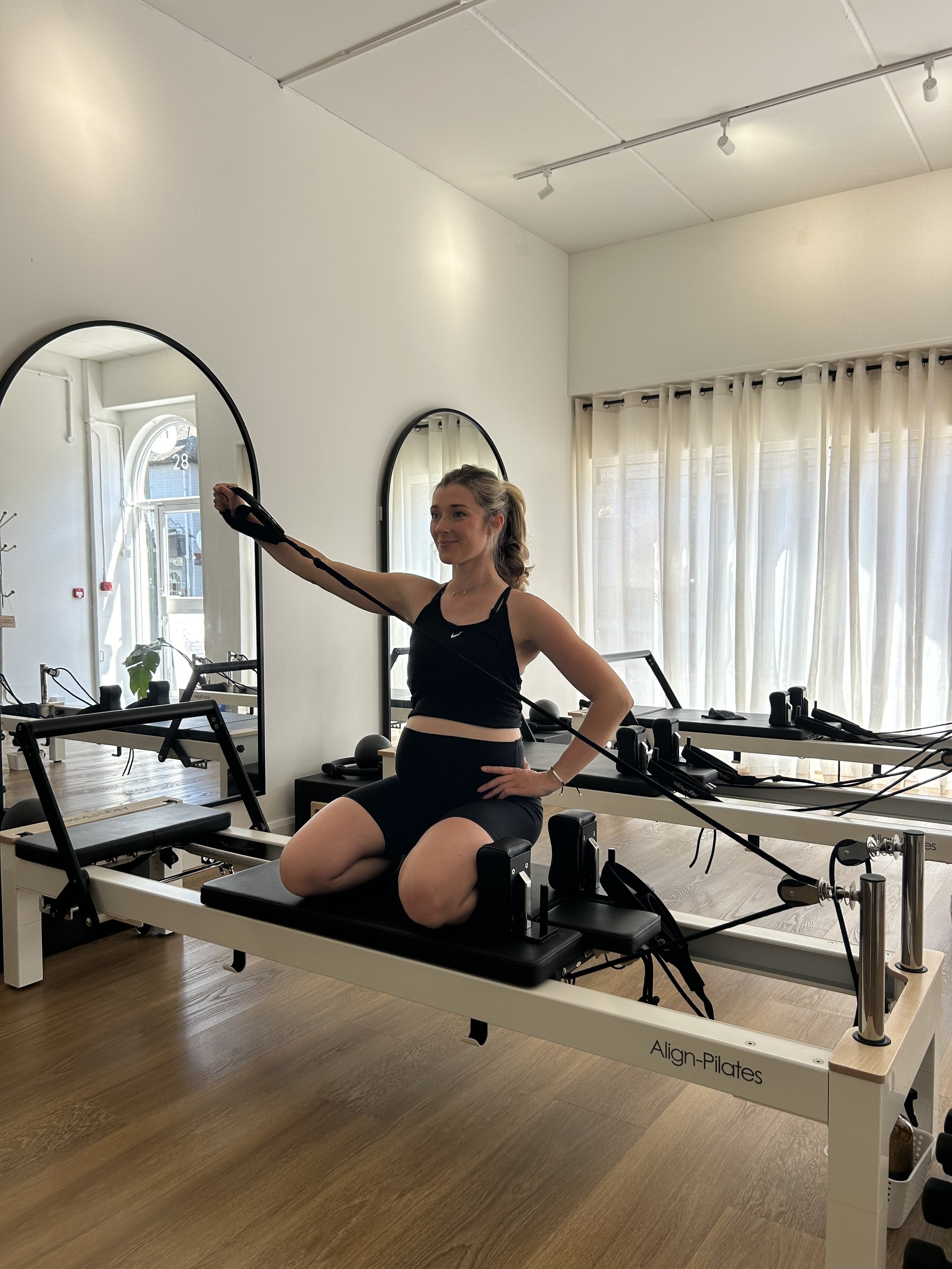 pregnant woman doing reformer pilates