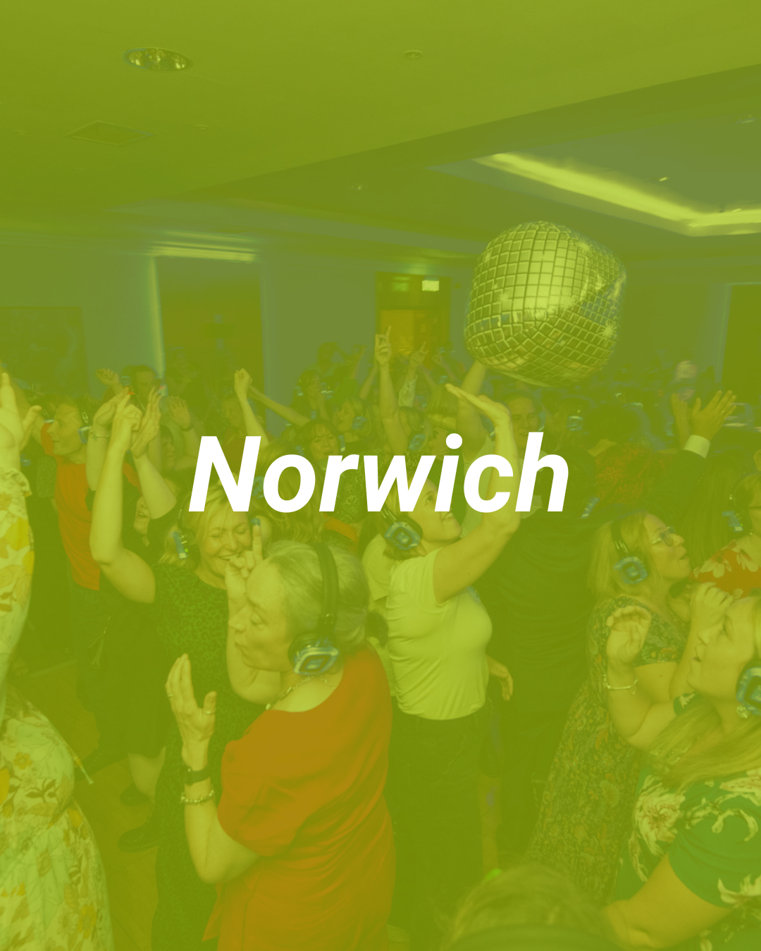 People dancing and enjoying music at a party with a disco ball overhead in Norwich.