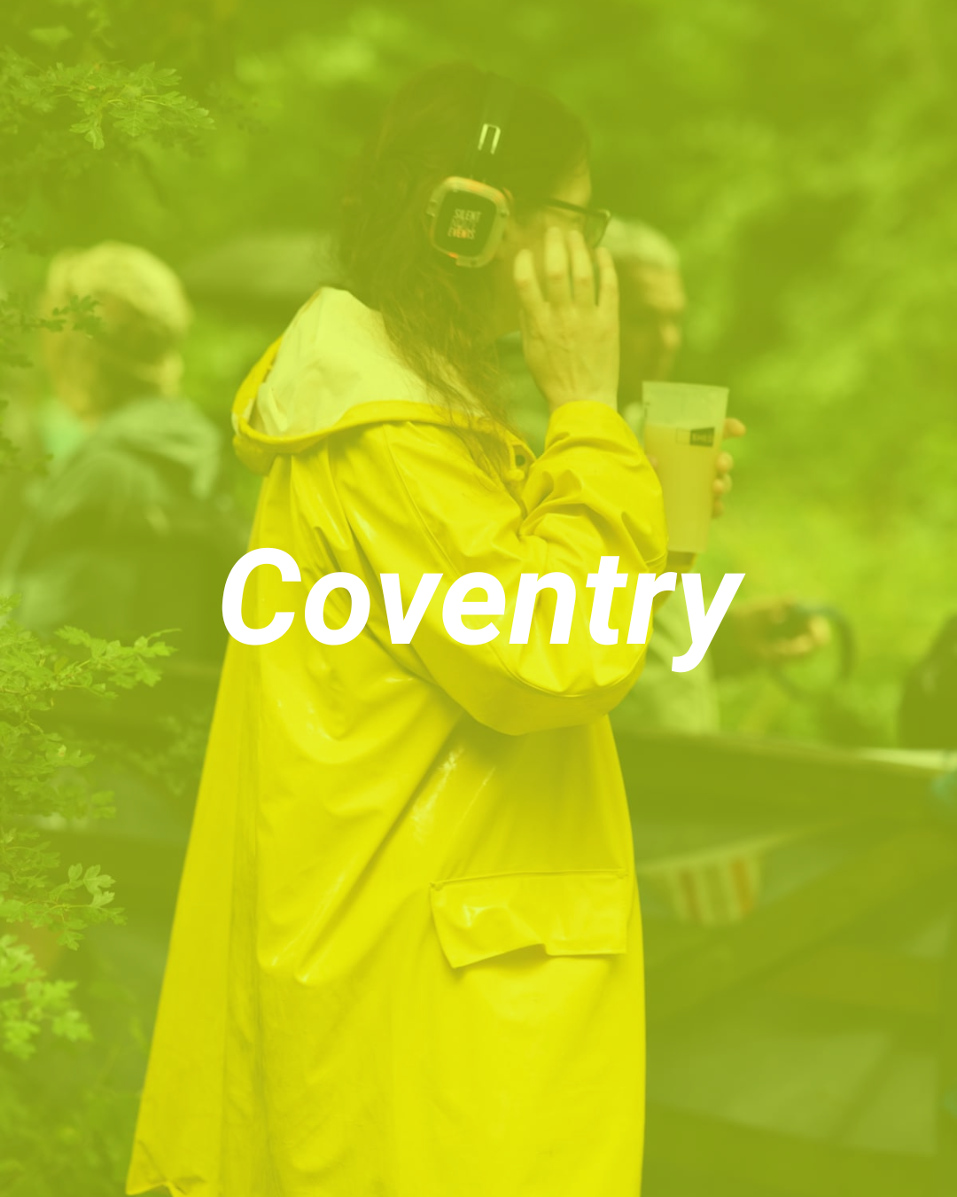 A person wearing a yellow raincoat and headphones holding a drink, standing outdoors with trees in the background. The word "Coventry" is overlaid on the image.