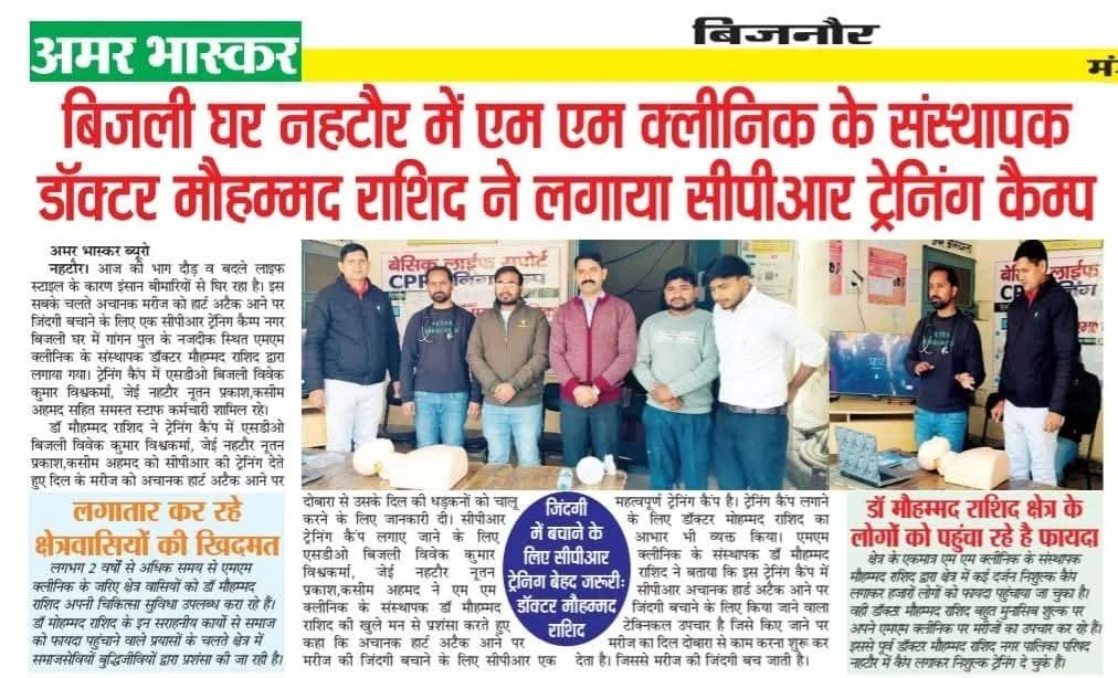 Group of people standing inside a room, some using laptops, with posters and wires on the walls, and a table with balls in the foreground.