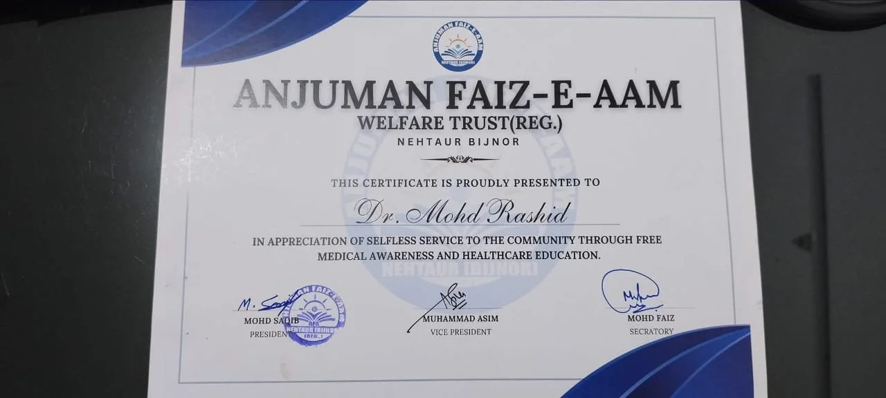 Certificate awarded to Dr. Mohd Rashid from Anjuman Faiz-e-Aam Welfare Trust for selfless service and health education, signed by Mohd Saqib, Muhammad Asim, and Mohd Faiz.