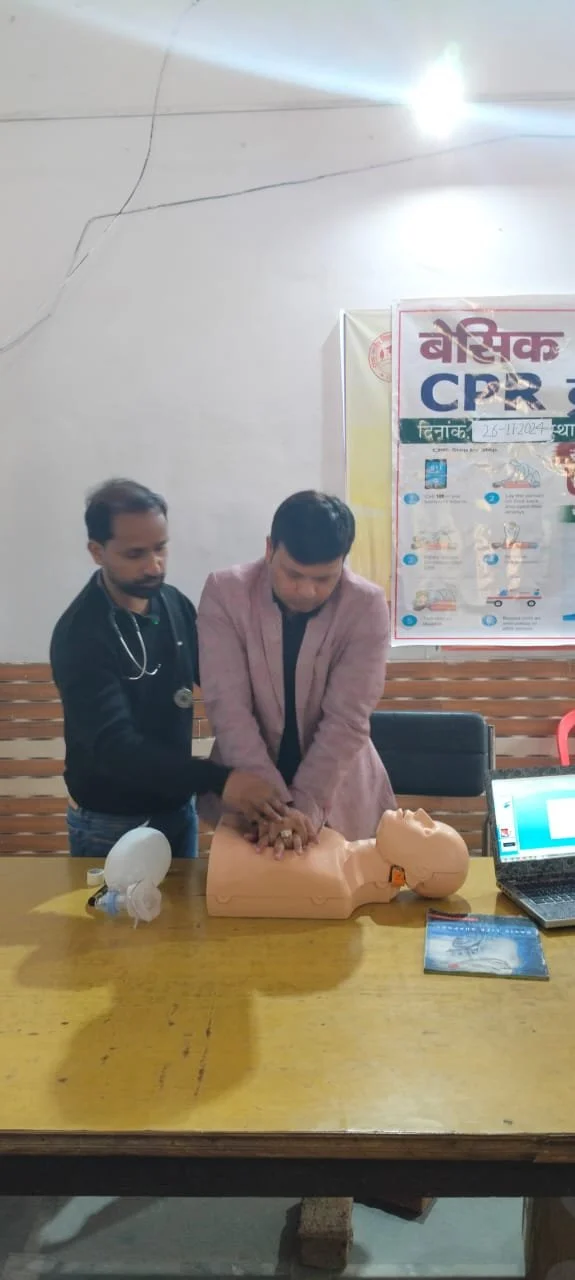 Two men practicing CPR on a training mannequin at a CPR certification class or workshop.