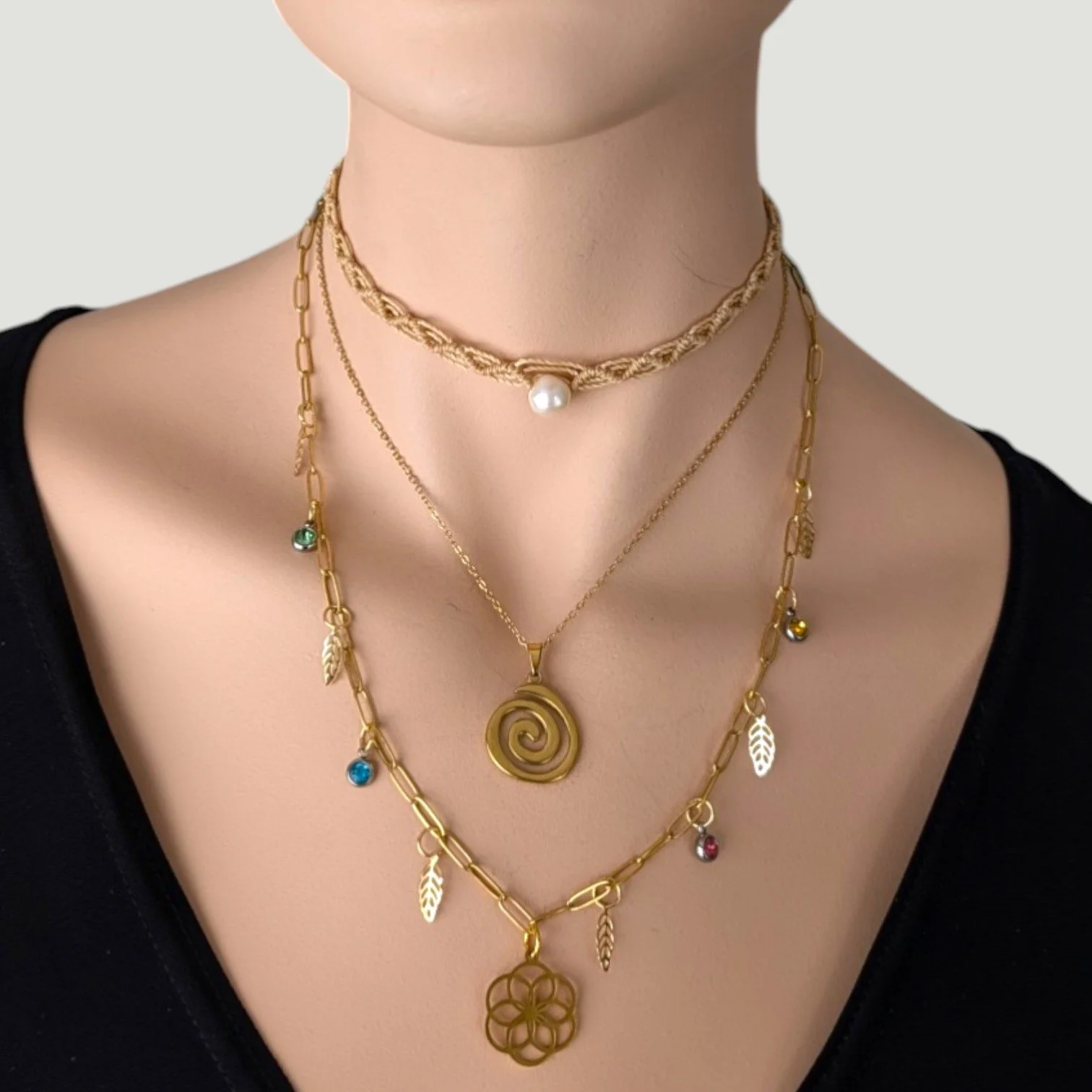 vortex spiral stainless steel necklace layered look on mannequin, pearl macrame choker, gold spiral & seed of life charm necklace
