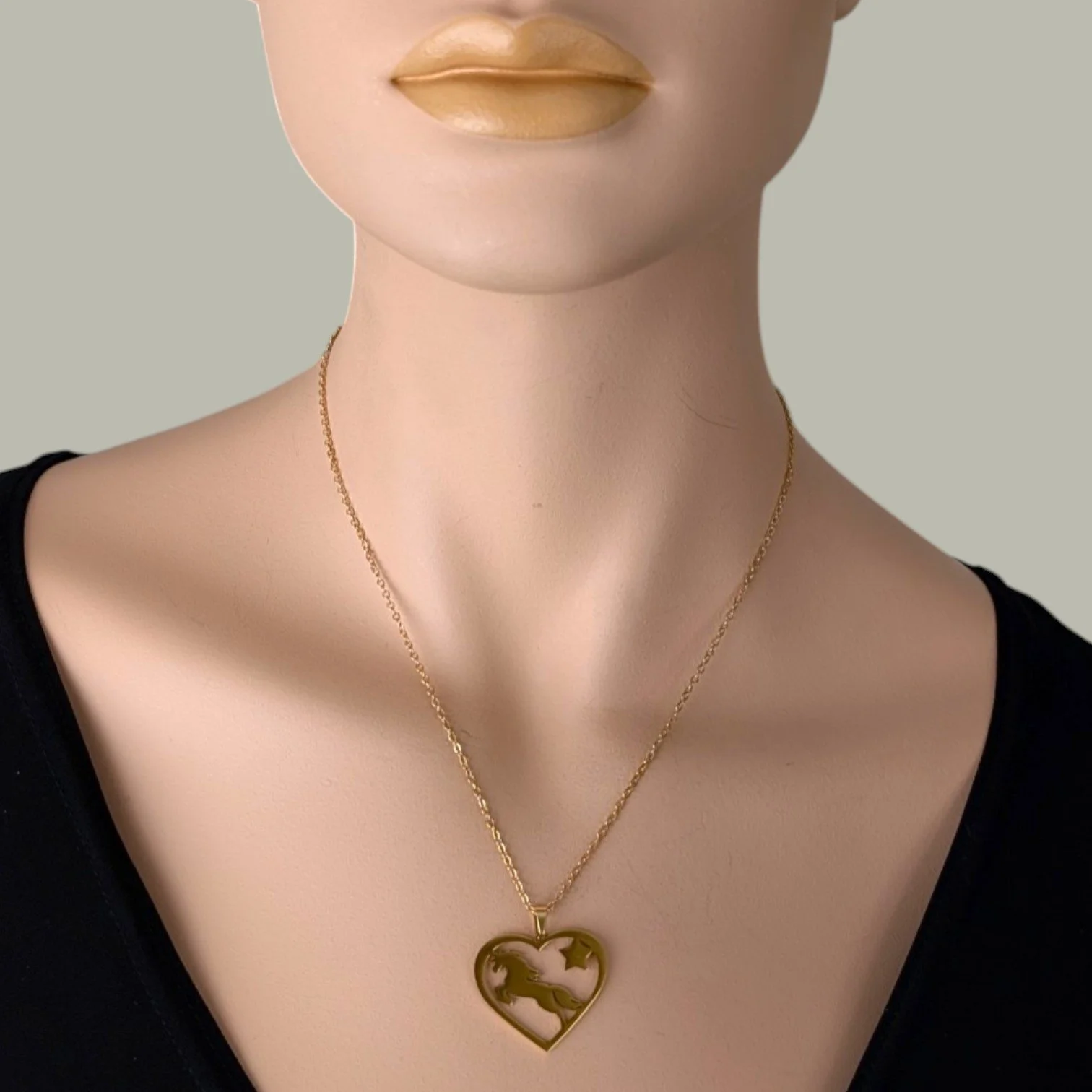 Gold stainless steel horse and heart necklace on mannequin, close up bust view
