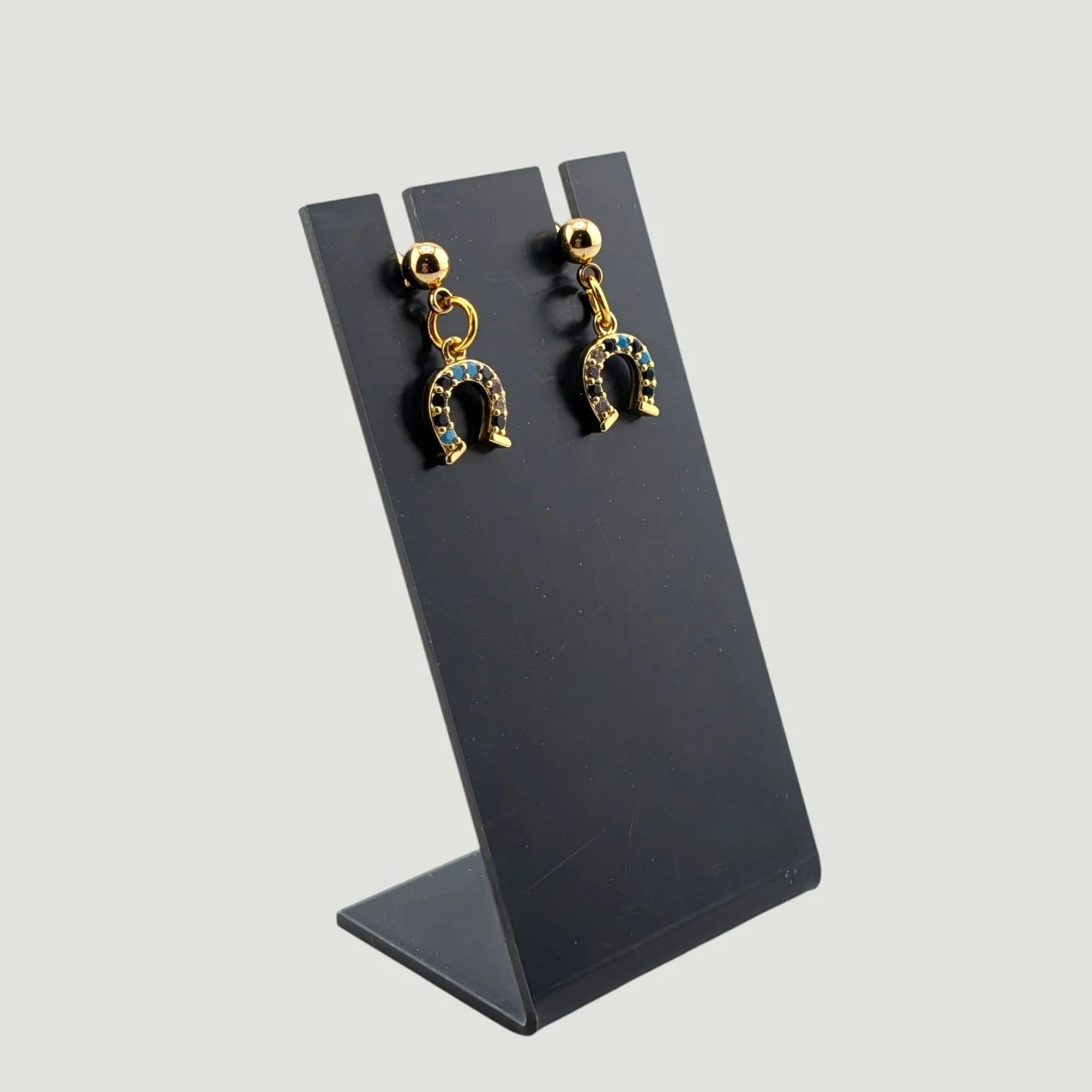 horseshoe stud drop earrings, gold tone, on earring stand, drop view