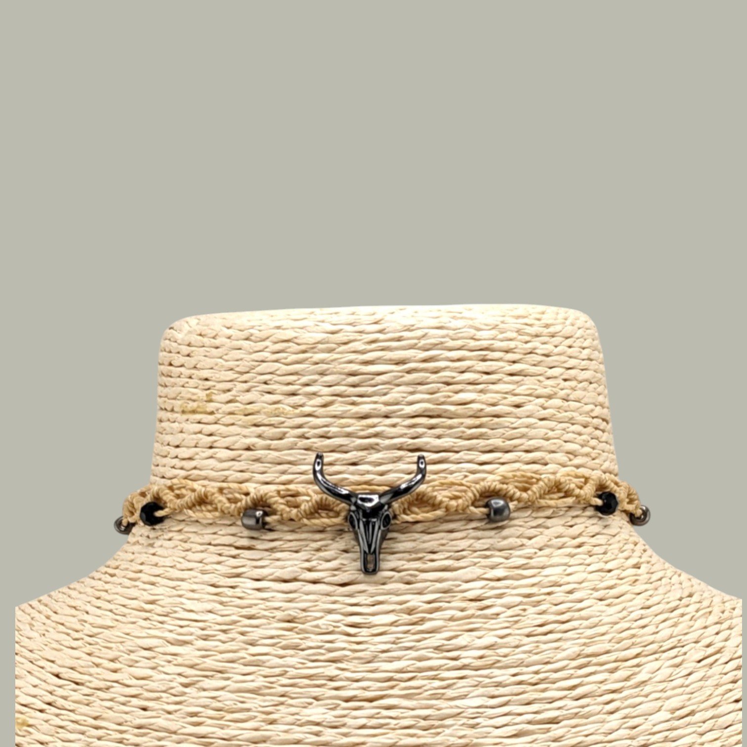 close-up front view of gunmetal tone bull skull macrame choker with glass bead details