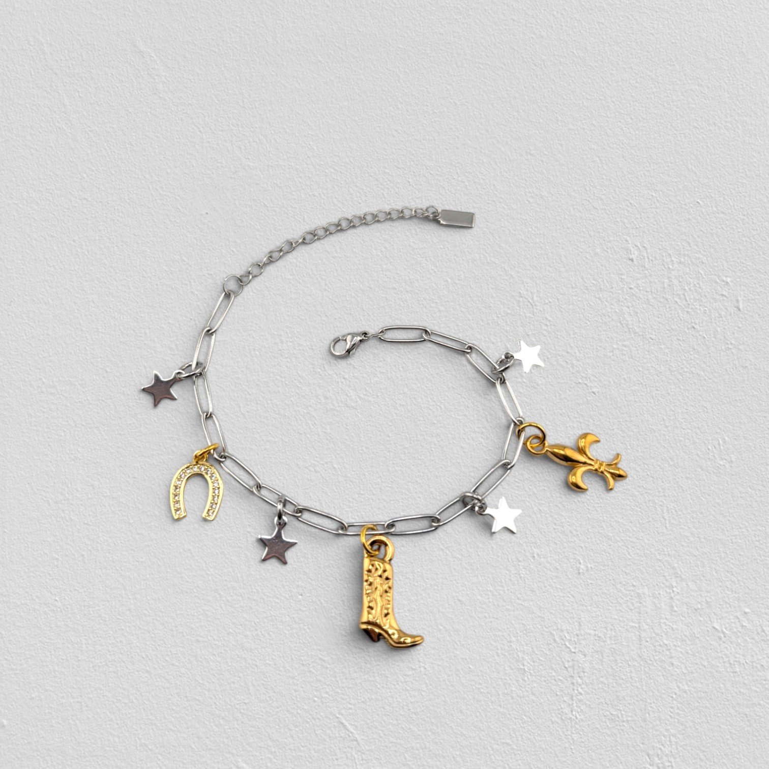Silver two-tone cowboy boot stainless steel charm bracelet, full flat lay