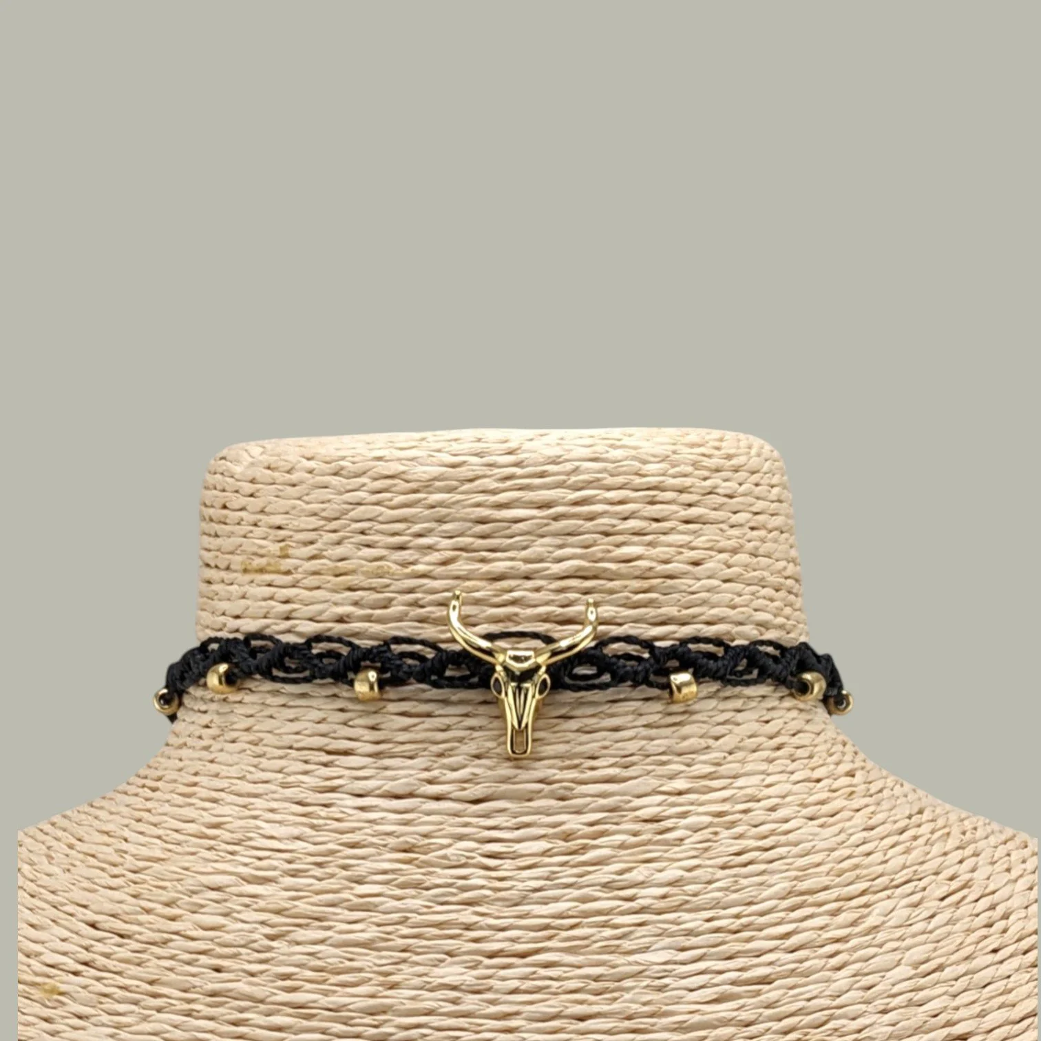 close-up front view of a bull skull woven macrame choker with gold-tone centerpiece and glass bead details