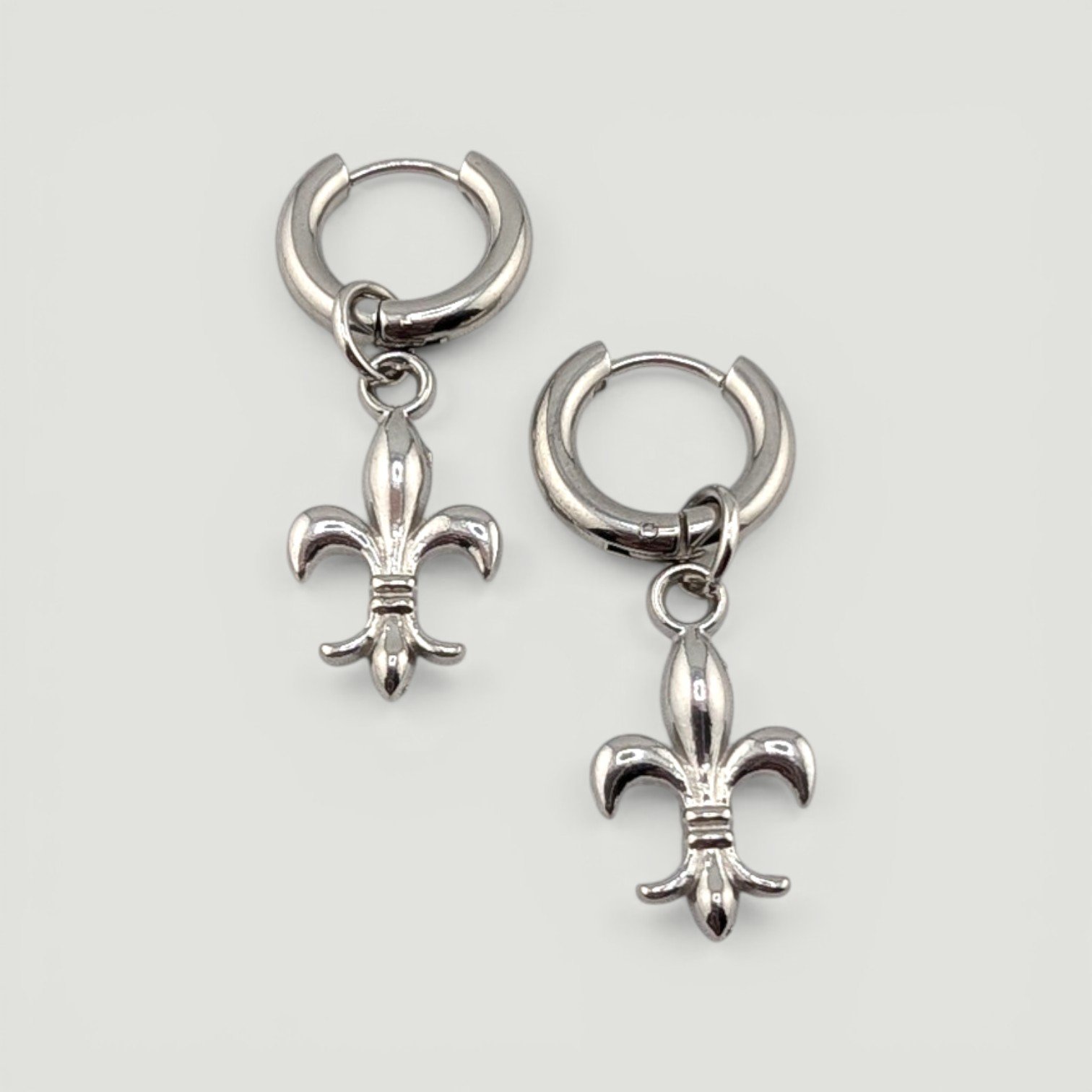 fleur de lis stainless steel huggie hoop earrings, silver, flat lay