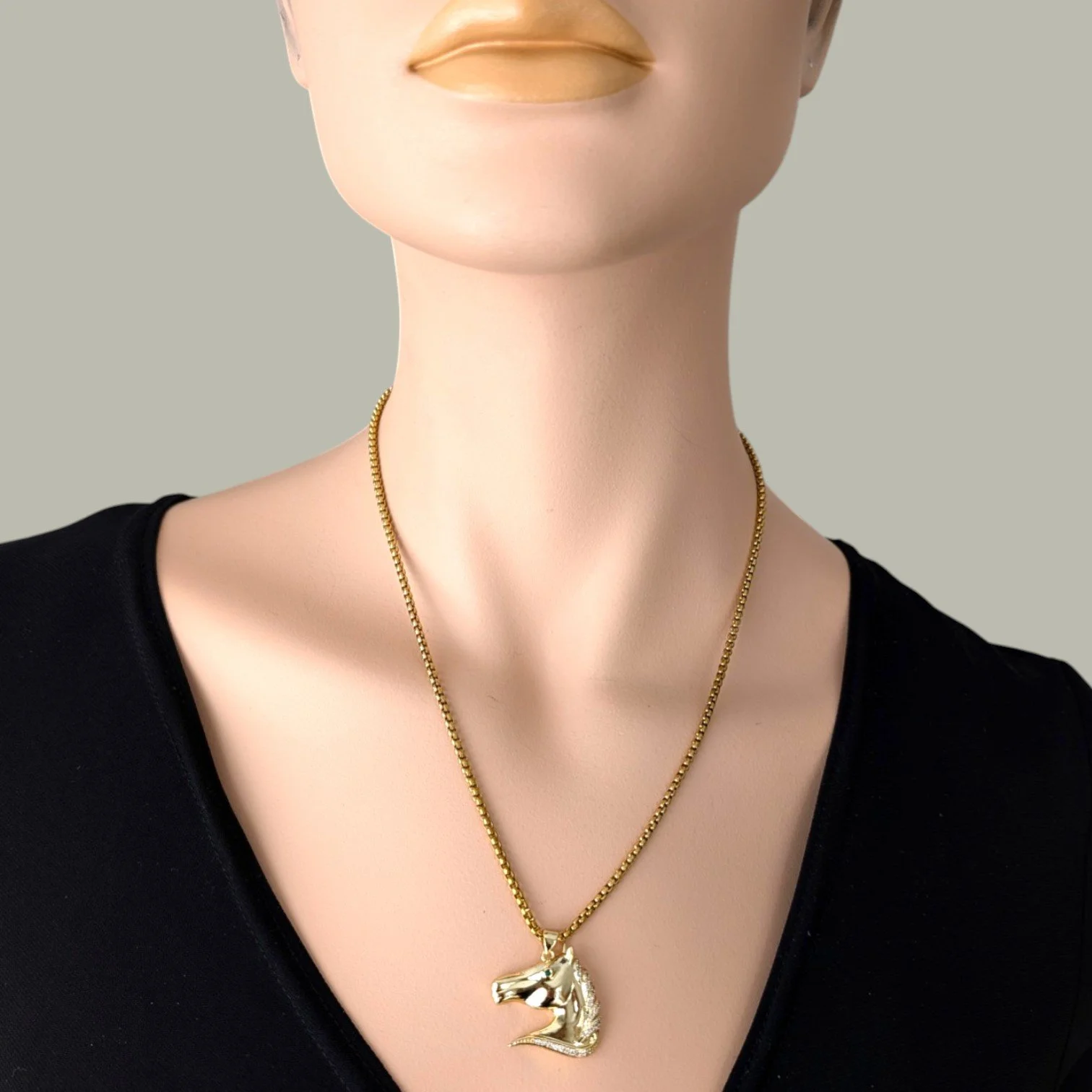 Rhinestone horse necklace on gold stainless steel chain worn on mannequin, close up bust view