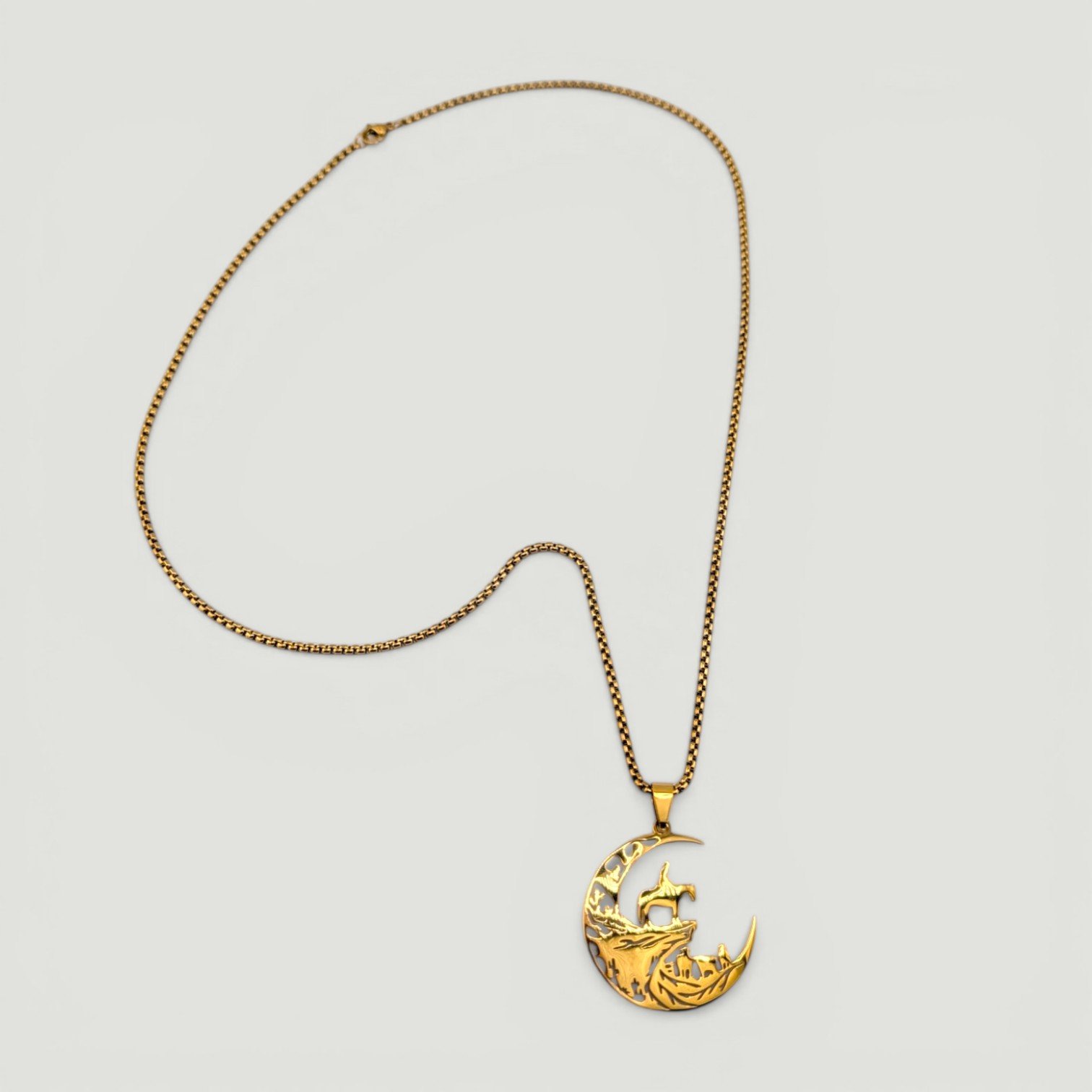 full view flat lay of men's cowboy moon gold stainless steel necklace showing chain and pendant