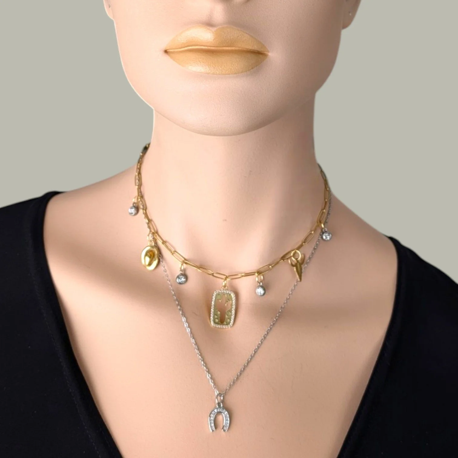silver rhinestone horseshoe necklace on a stainless steel chain layered with a cactus charm choker on mannequin, close up bust view